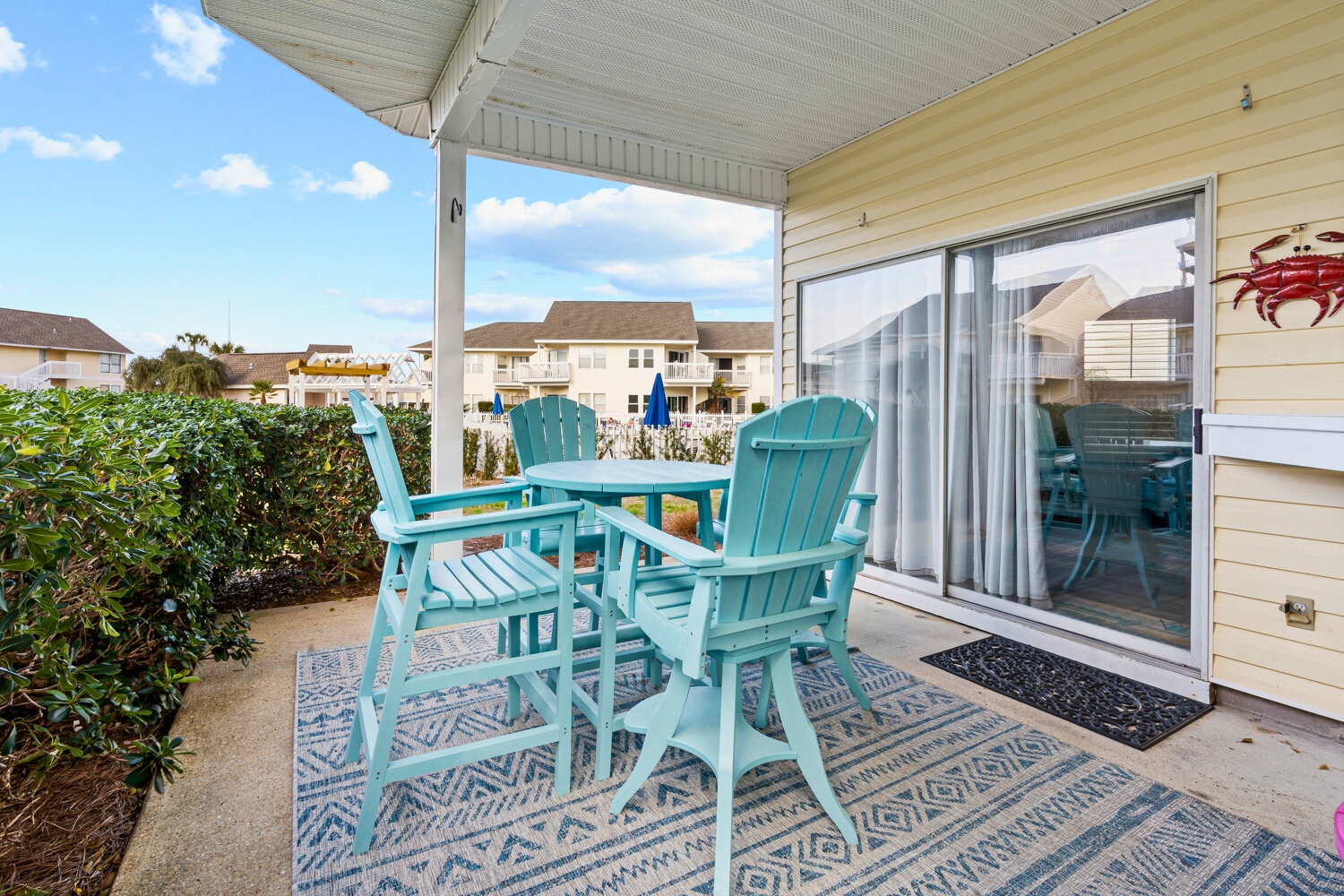 Unwind on your private patio with coastal-colored chairs, perfect for morning coffee or evening relaxation overlooking the peaceful neighborhood.