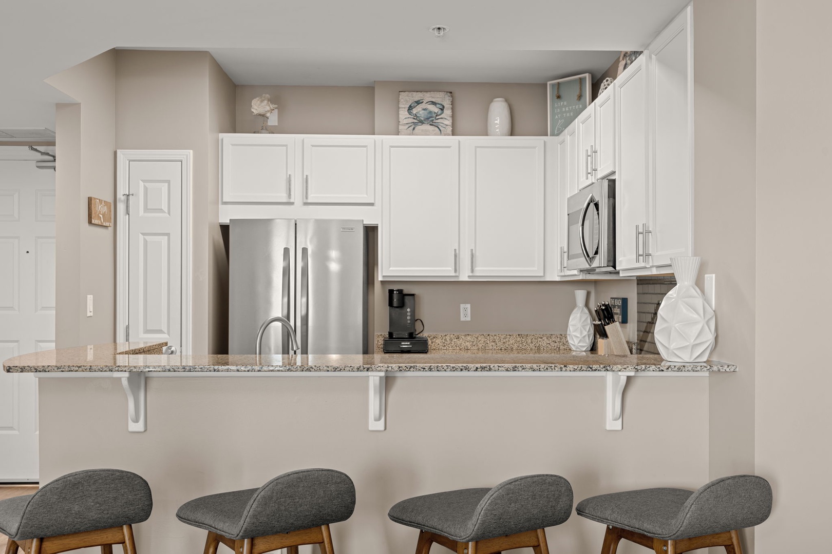 Gather around this sleek breakfast bar with granite countertops, where morning coffee and easy meals feel effortless. The fully equipped kitchen with stainless steel appliances makes cooking a pleasure.