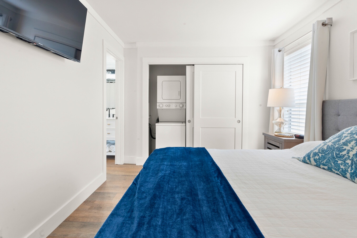 Unwind in your serene bedroom with crisp linens, modern conveniences, and a peaceful blue accent that invites restful nights.