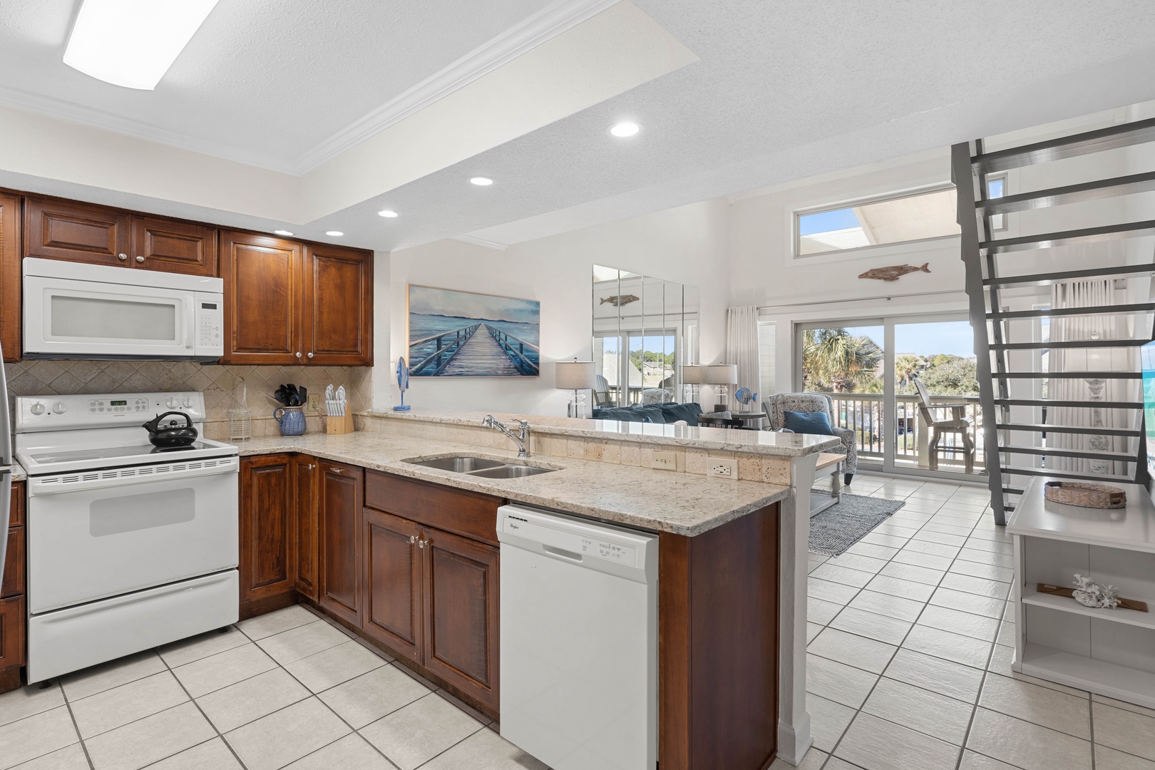 Your spacious kitchen boasts granite counters, rich wood cabinets, and modern appliances perfect for preparing coastal meals together.