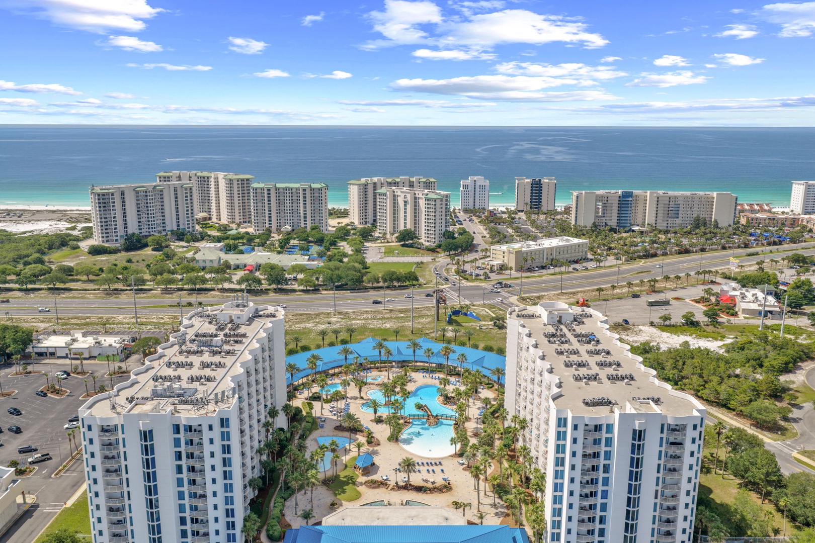 Aerial view of a beachfront resort community featuring tropical pools and direct access to white-sand shores along the Gulf Coast.