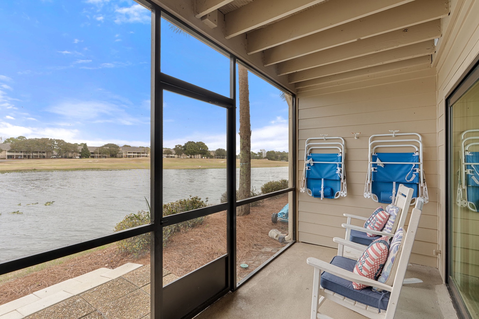 Enjoy stunning lake views from your private screened porch, where peaceful waters and blue skies create the perfect backdrop for your morning coffee or evening relaxation.