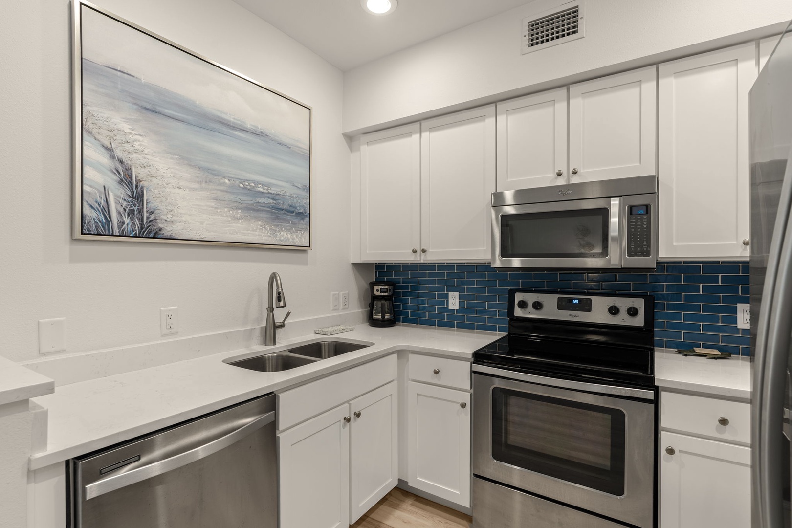 Your fully equipped kitchen awaits with sleek stainless appliances, ample counter space, and stylish blue subway tile backsplash—perfect for whipping up meals during your stay.