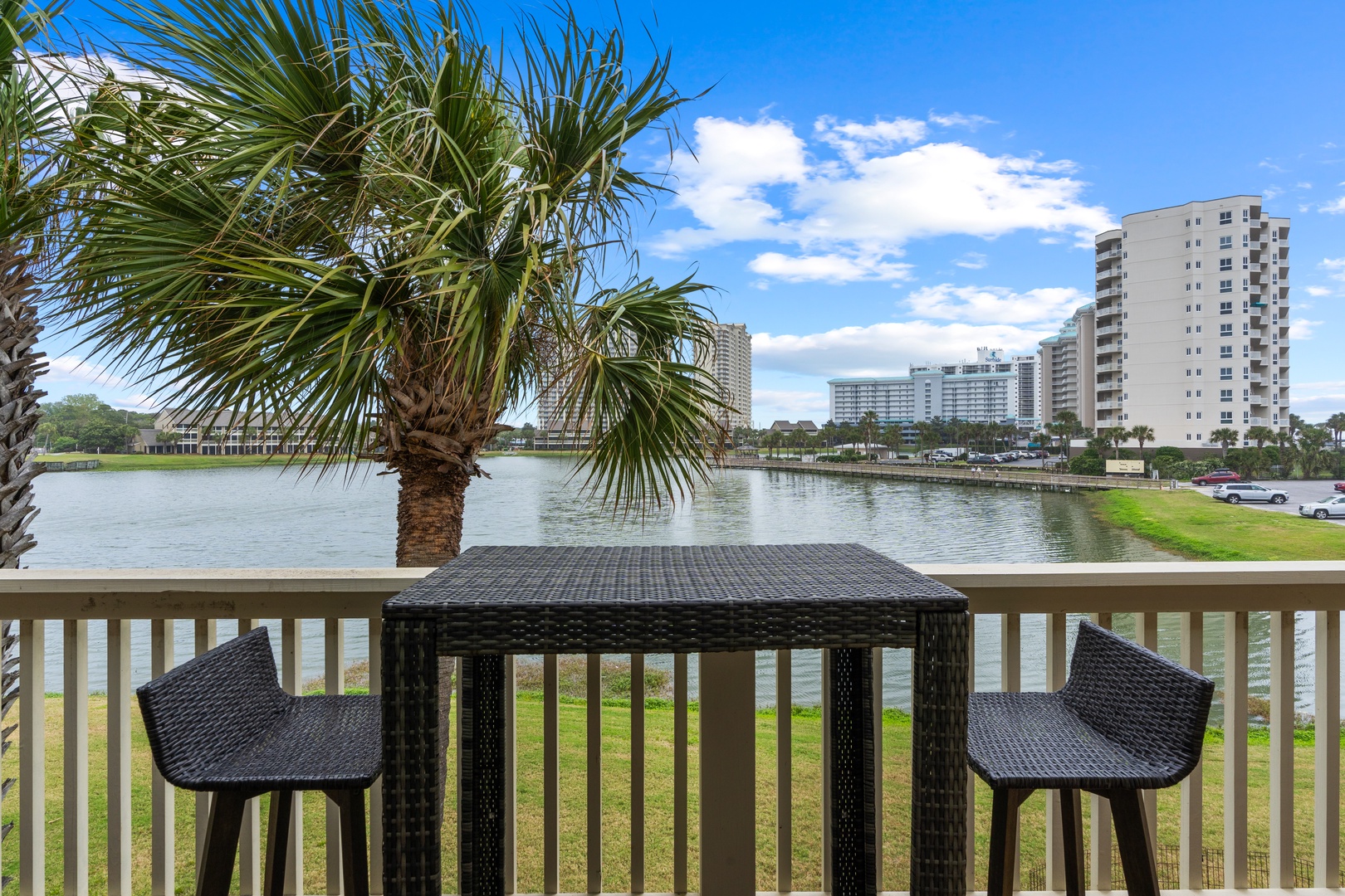 Sip your morning coffee at this waterfront bistro table, where peaceful lake views and swaying palms create the perfect backdrop for relaxation.