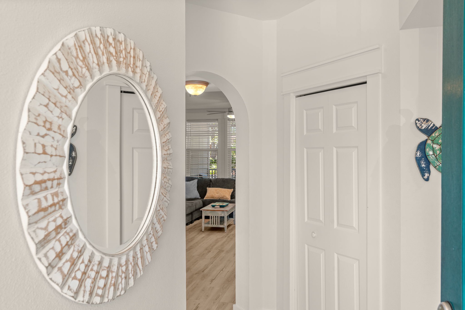 Step through the arched entryway into your welcoming retreat, where coastal charm meets comfortable living spaces designed for your relaxation.