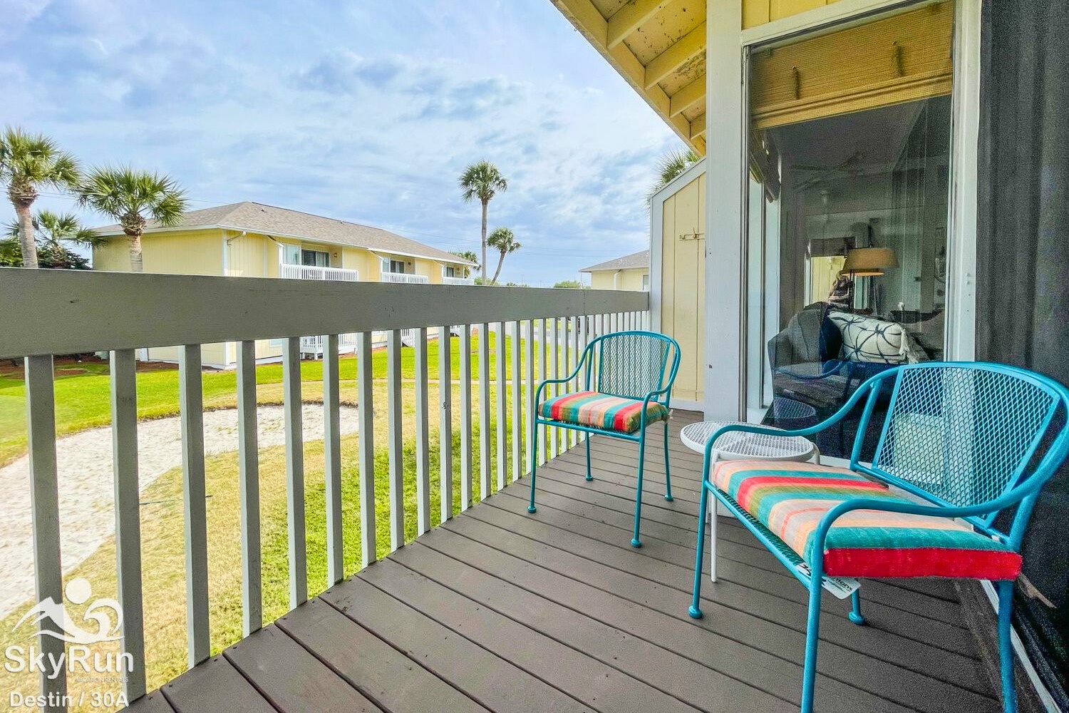 Step onto your private balcony with cheerful turquoise seating and colorful cushions, perfect for morning coffee or evening relaxation.