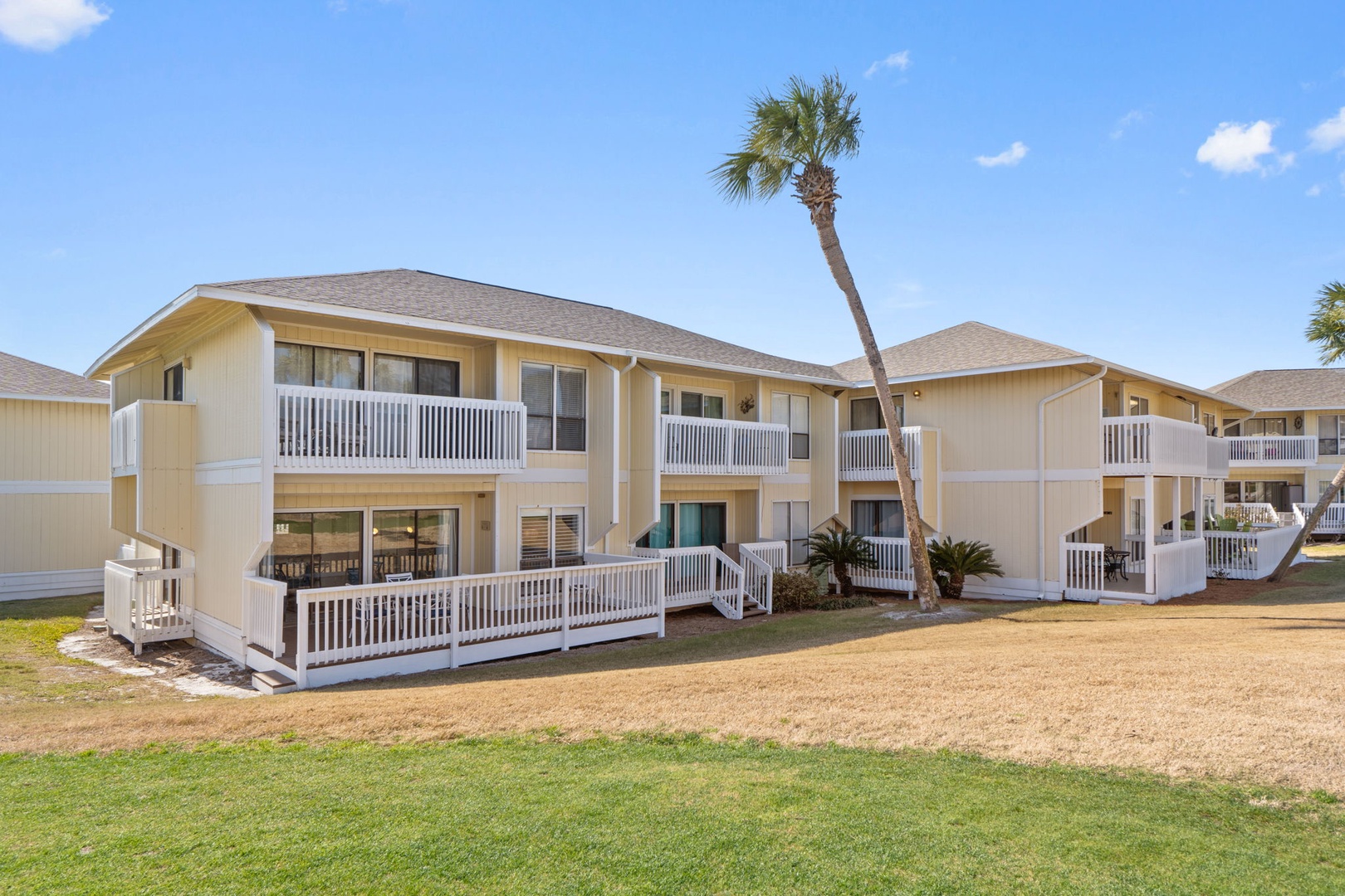 Coastal-inspired buildings featuring private balconies and tropical landscaping define the property's relaxed, beachside atmosphere.