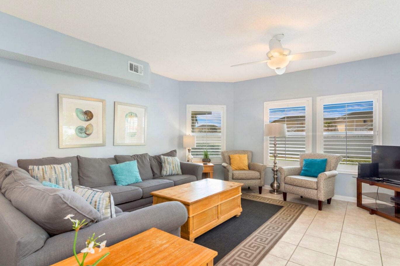 Inviting coastal living room with plush seating, soft natural light, calming beach tones, and a comfortable layout perfect for relaxing after a day at the shore.