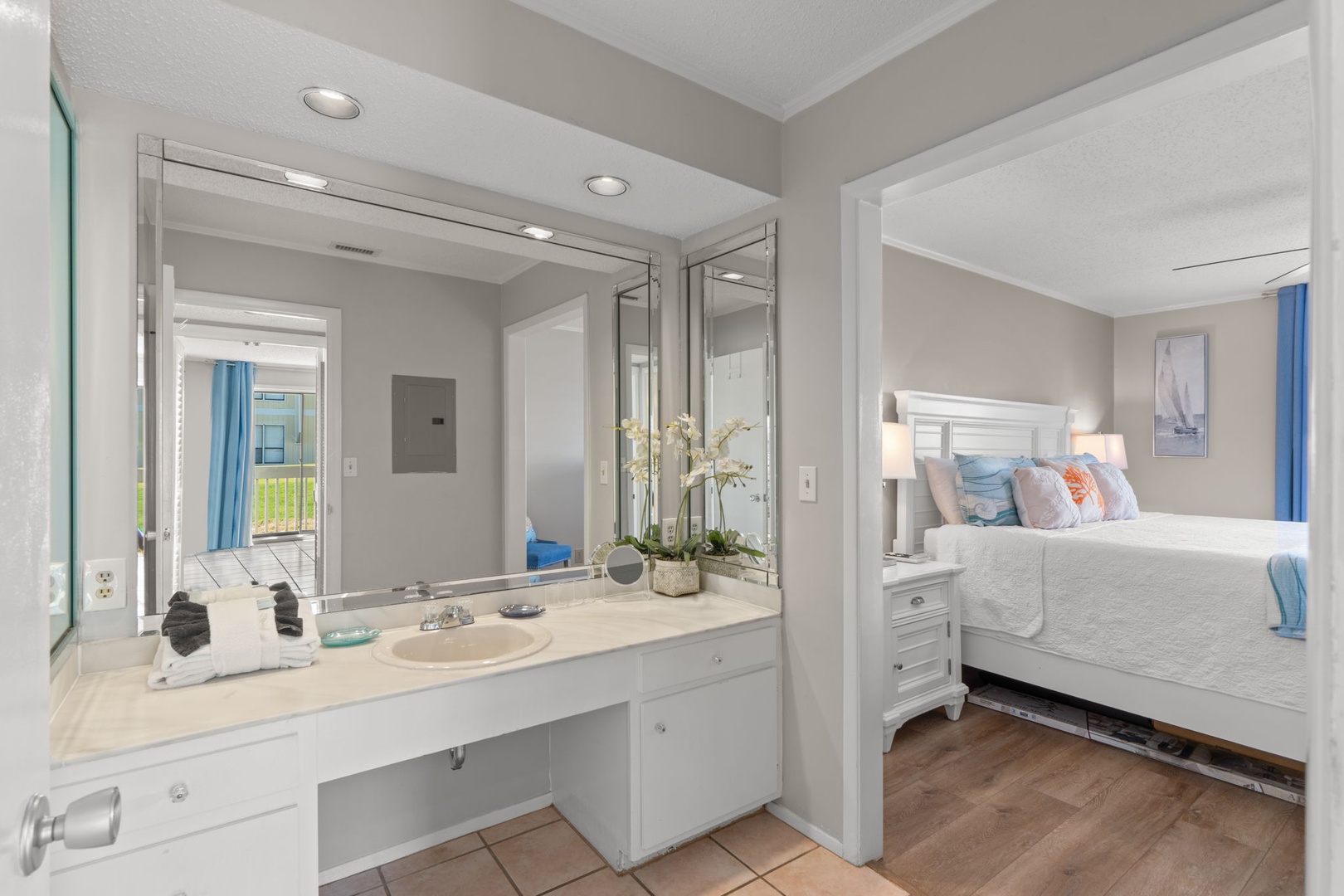 The spacious dressing area offers a large vanity, bright lighting, and plenty of counter space, creating a comfortable spot to get ready while remaining conveniently connected to the primary bedroom.