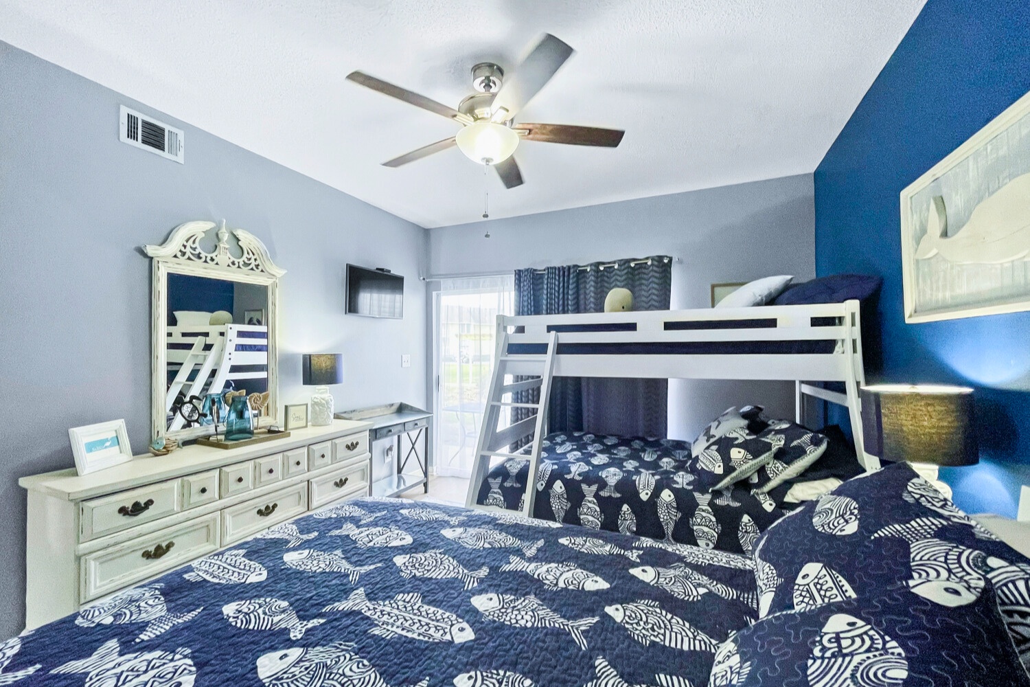 Drift off to sleep in this coastal-themed bedroom featuring comfortable beds and a charming bunk bed perfect for family adventures.