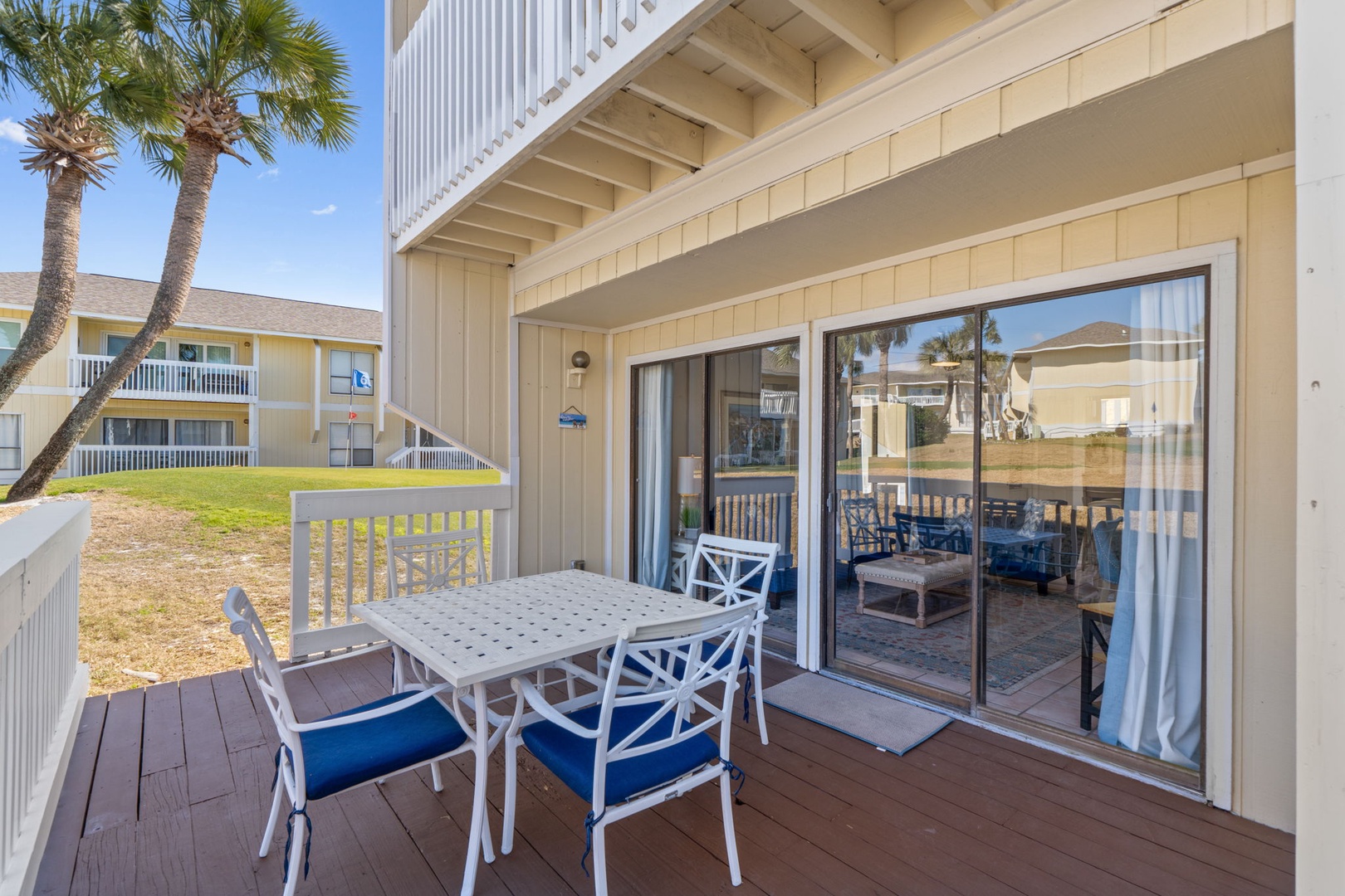 A coastal-style ground-floor patio perfect for morning coffee or evening relaxation, with easy access to your private outdoor space and views of swaying palms.