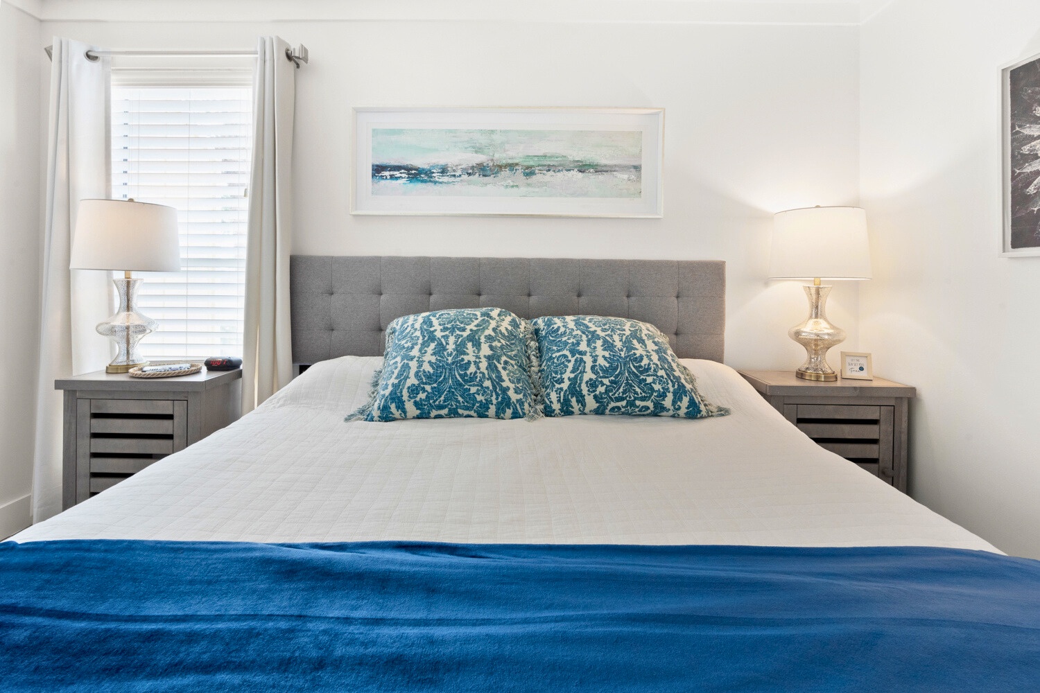 Sink into coastal comfort in your serene bedroom, where ocean-inspired blues and soft lighting create the perfect retreat for restful nights.