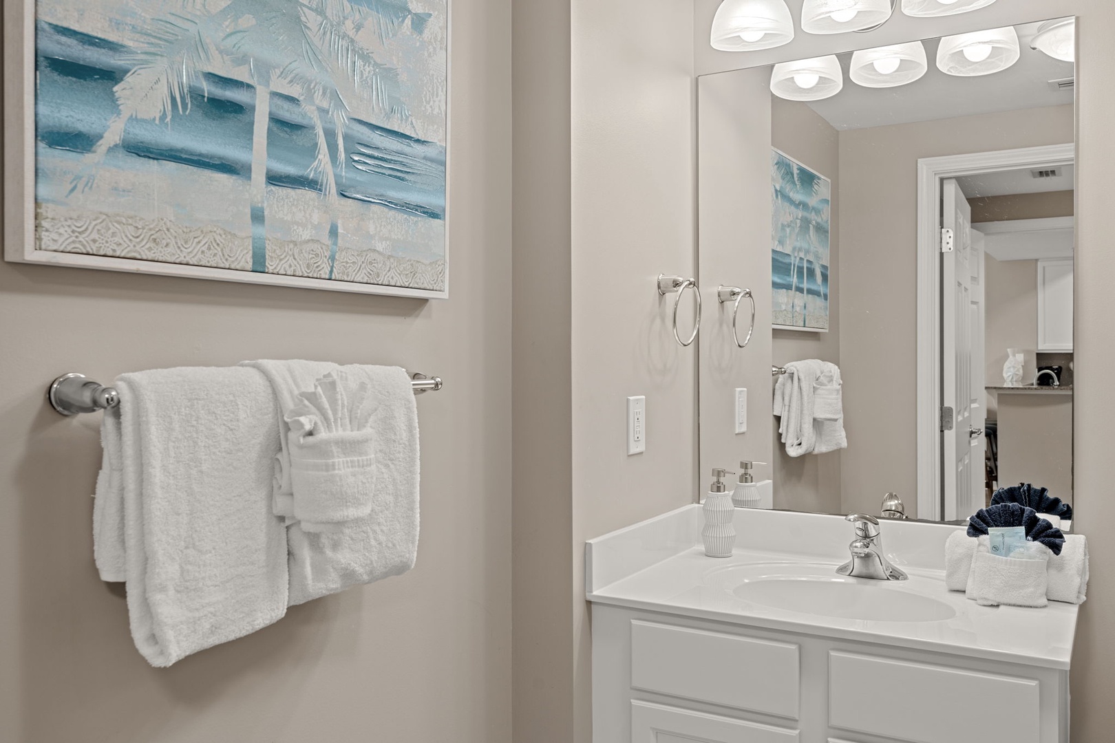 Step into your private spa-like retreat with plush towels, coastal-inspired art, and modern fixtures designed for your comfort and relaxation.