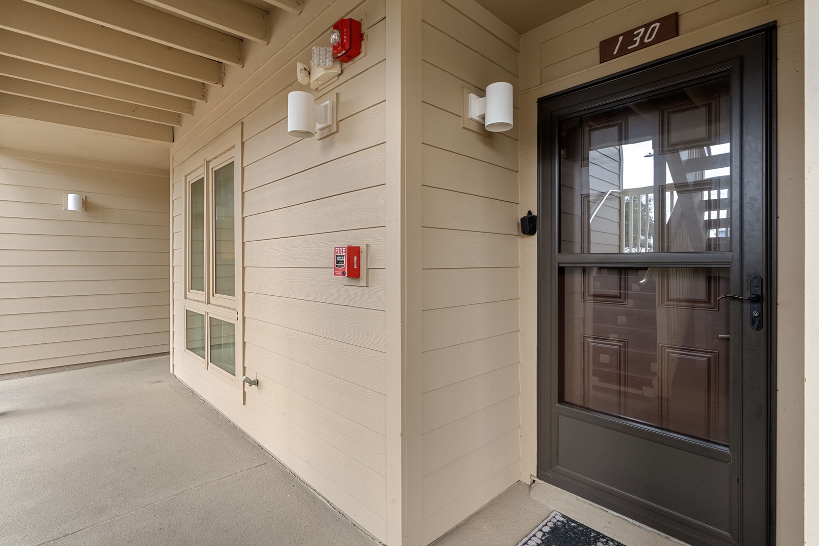 Covered walkway entrance with modern lighting and clear unit numbers for easy arrival identification.