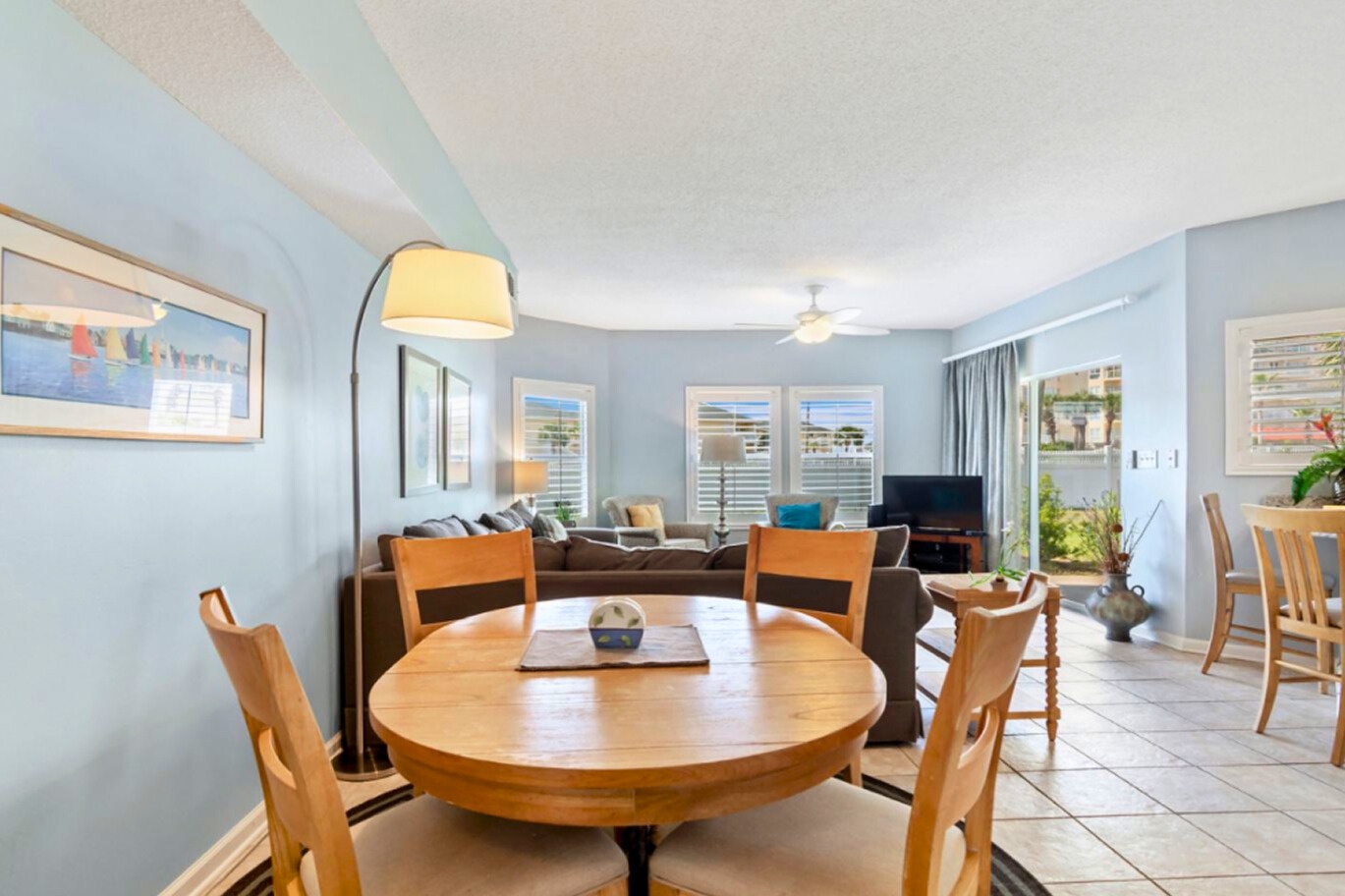 Your bright open-plan living space combines dining and relaxation perfectly, with soothing blue walls and warm wood touches creating a welcoming coastal vibe.