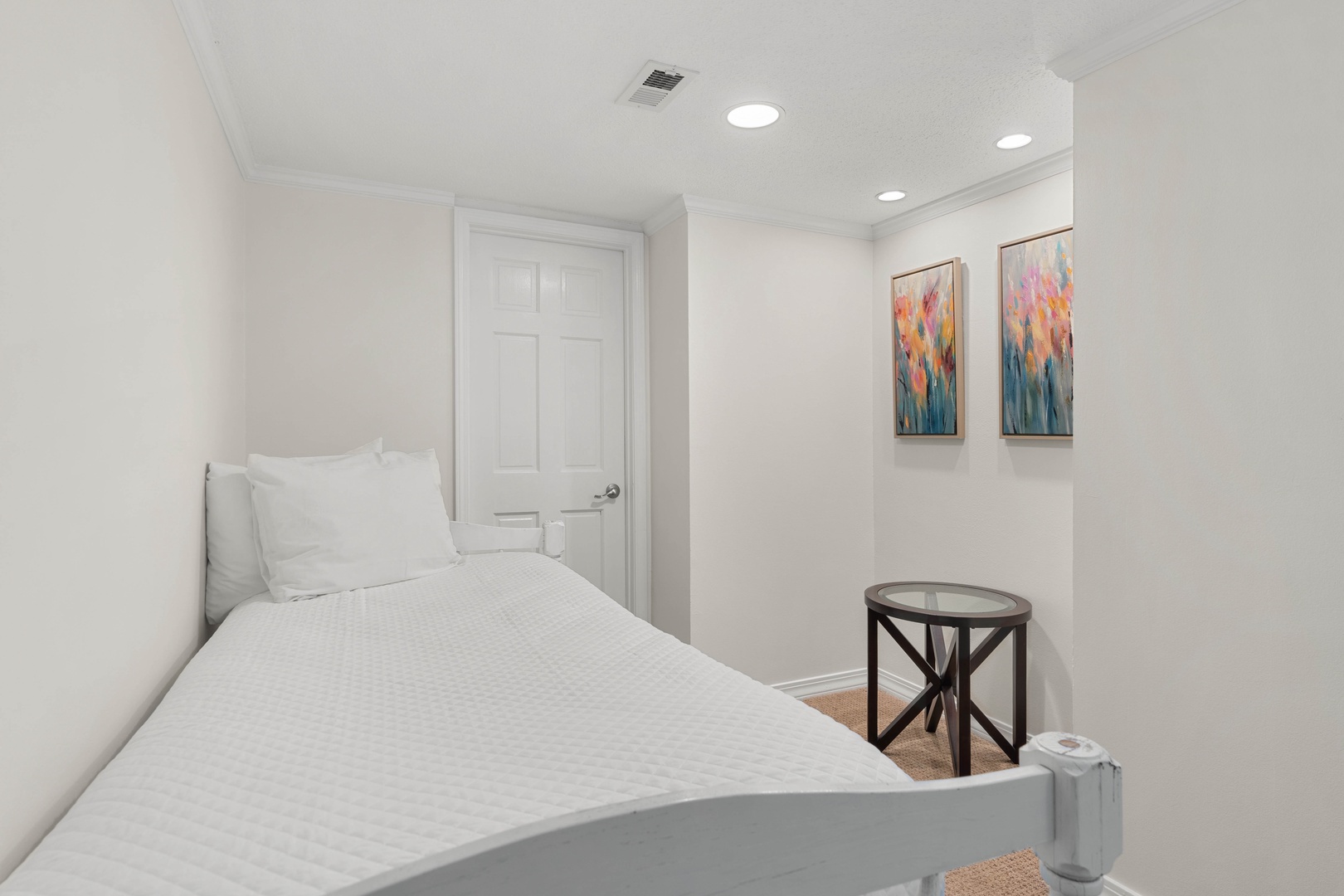 Rest peacefully in your cozy bedroom featuring crisp white linens, vibrant artwork, and thoughtful touches that make this space feel like home.