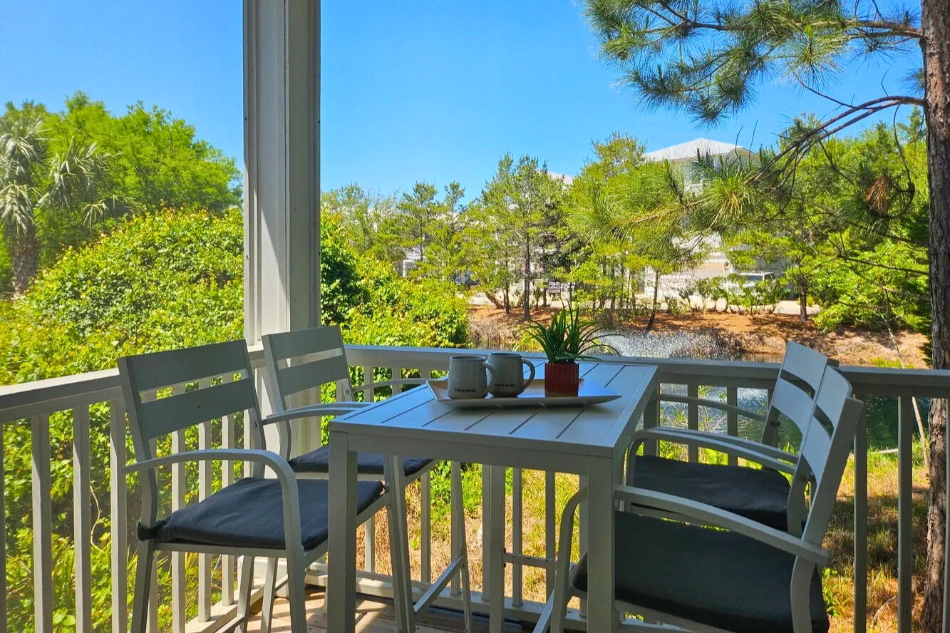 Dine or unwind on the screened porch, surrounded by lush greenery and coastal breezes—an easygoing space to relax and enjoy vacation moments.