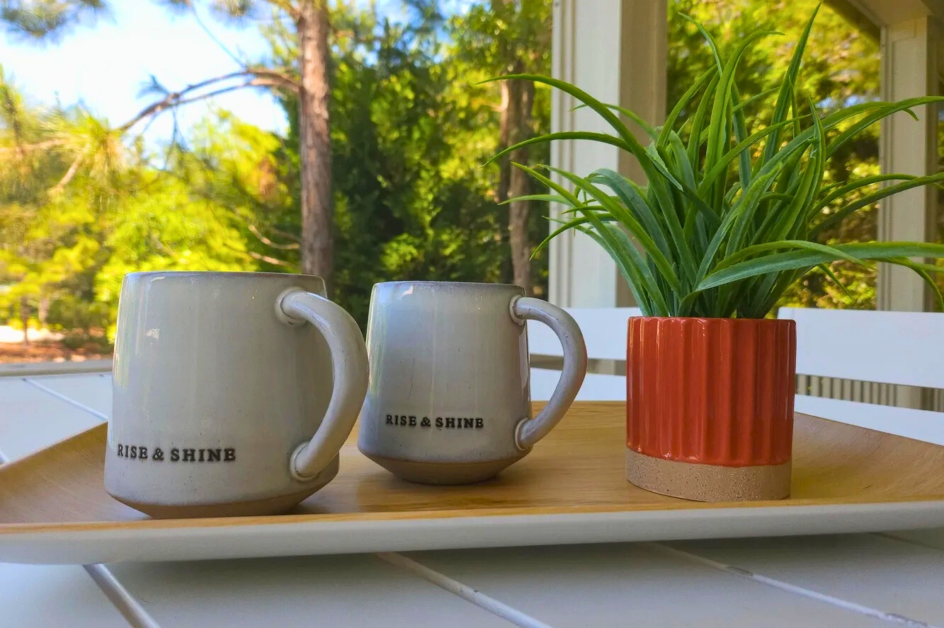 Sip your morning coffee on the screened porch, surrounded by greenery and coastal calm—an inviting spot to slow down, relax, and ease into vacation mode.