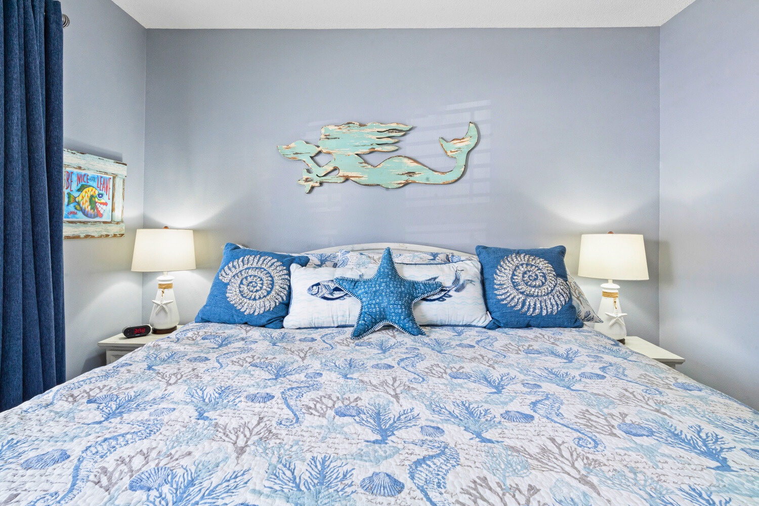 Sink into coastal comfort with ocean-themed bedding and charming mermaid wall art creating your seaside sanctuary.