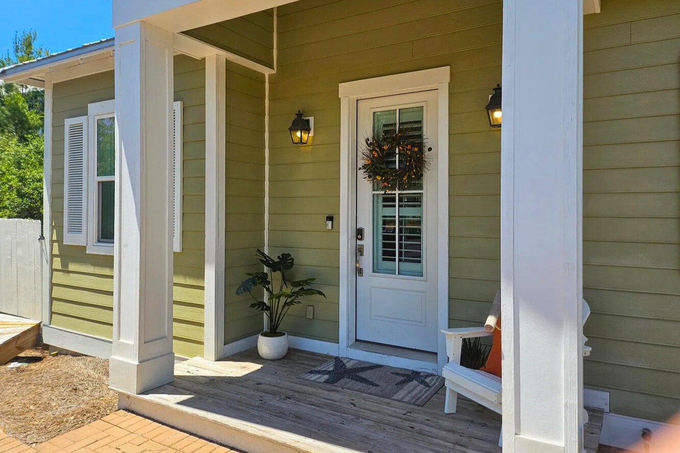 A warm coastal welcome begins at this charming front porch, featuring soft lighting, coastal accents, and an inviting entry that sets the tone for a relaxed Florida getaway.