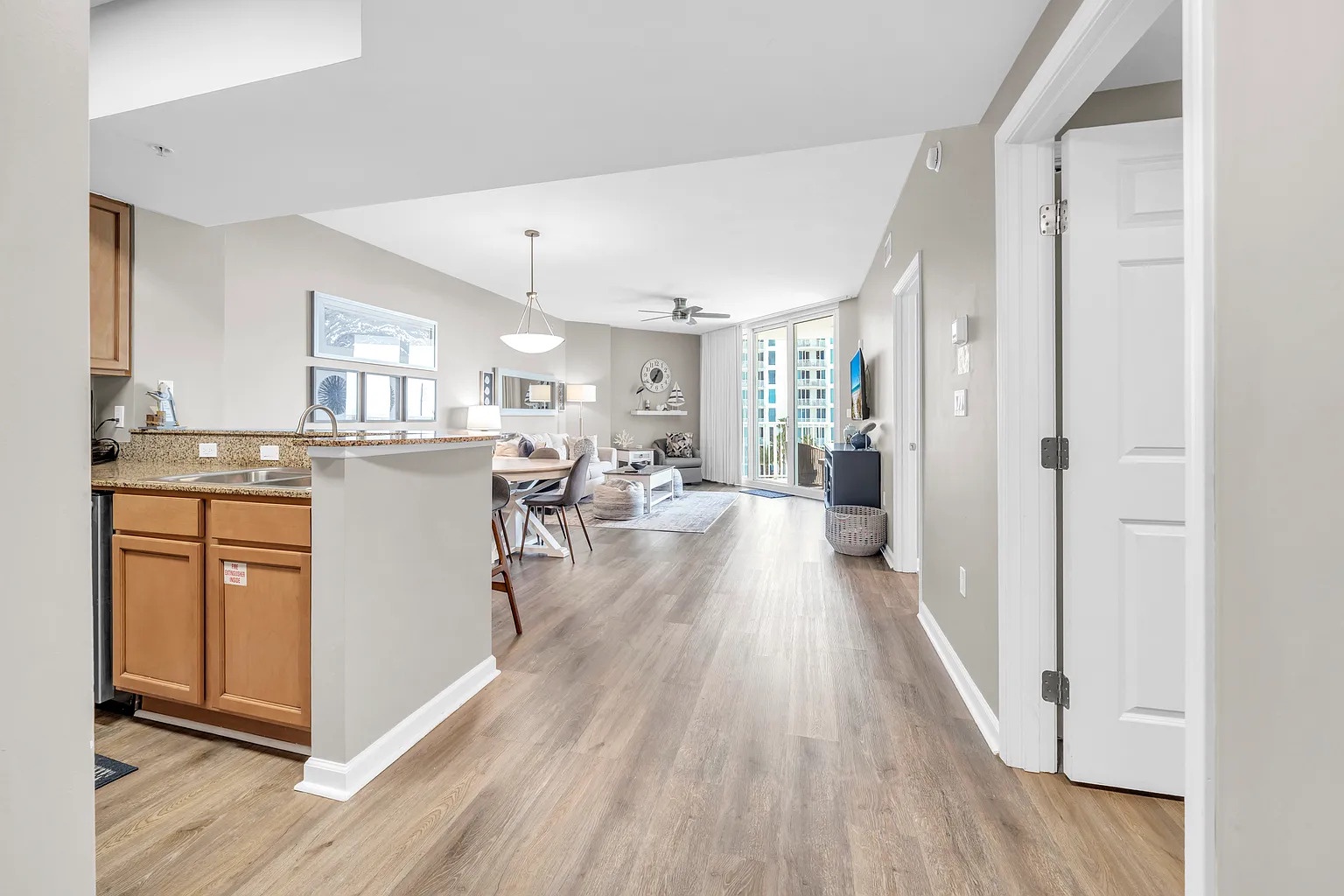 Step into your spacious open-concept haven with gleaming floors that flow seamlessly from kitchen to living room, bathed in natural light.