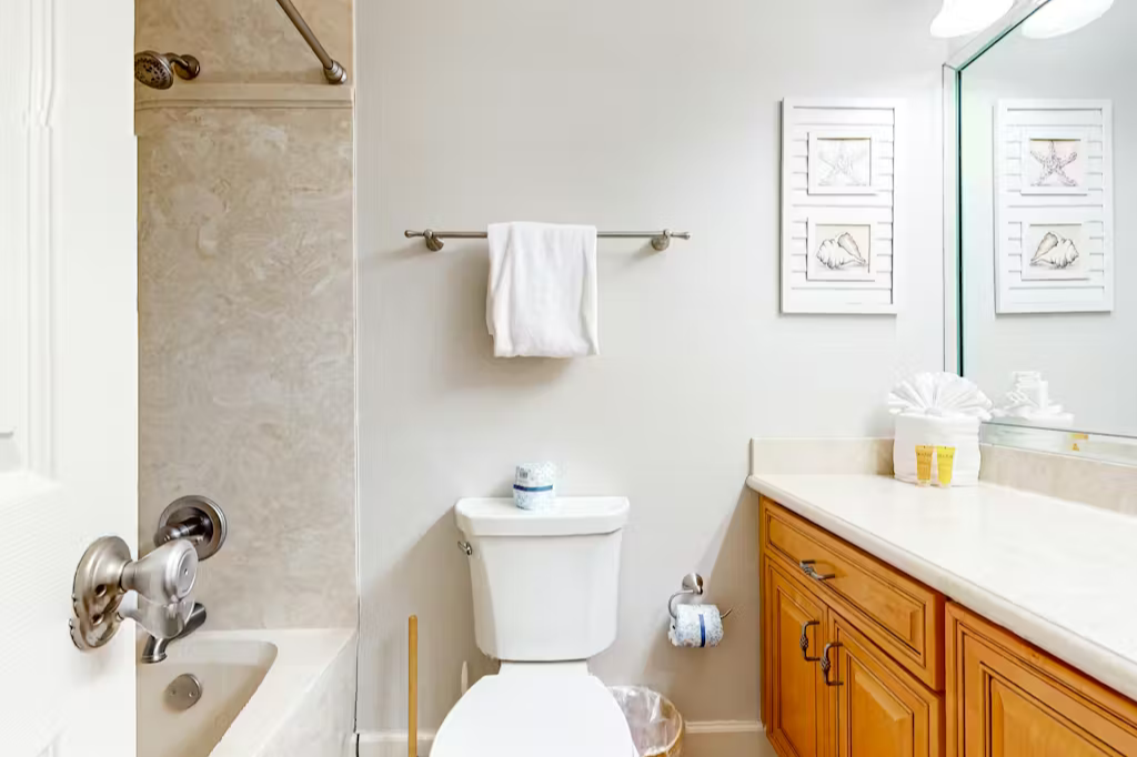 Your bathroom is bright, clean, and thoughtfully arranged, with soft white towels and coastal-inspired art that bring a breezy, relaxed feel to the space.