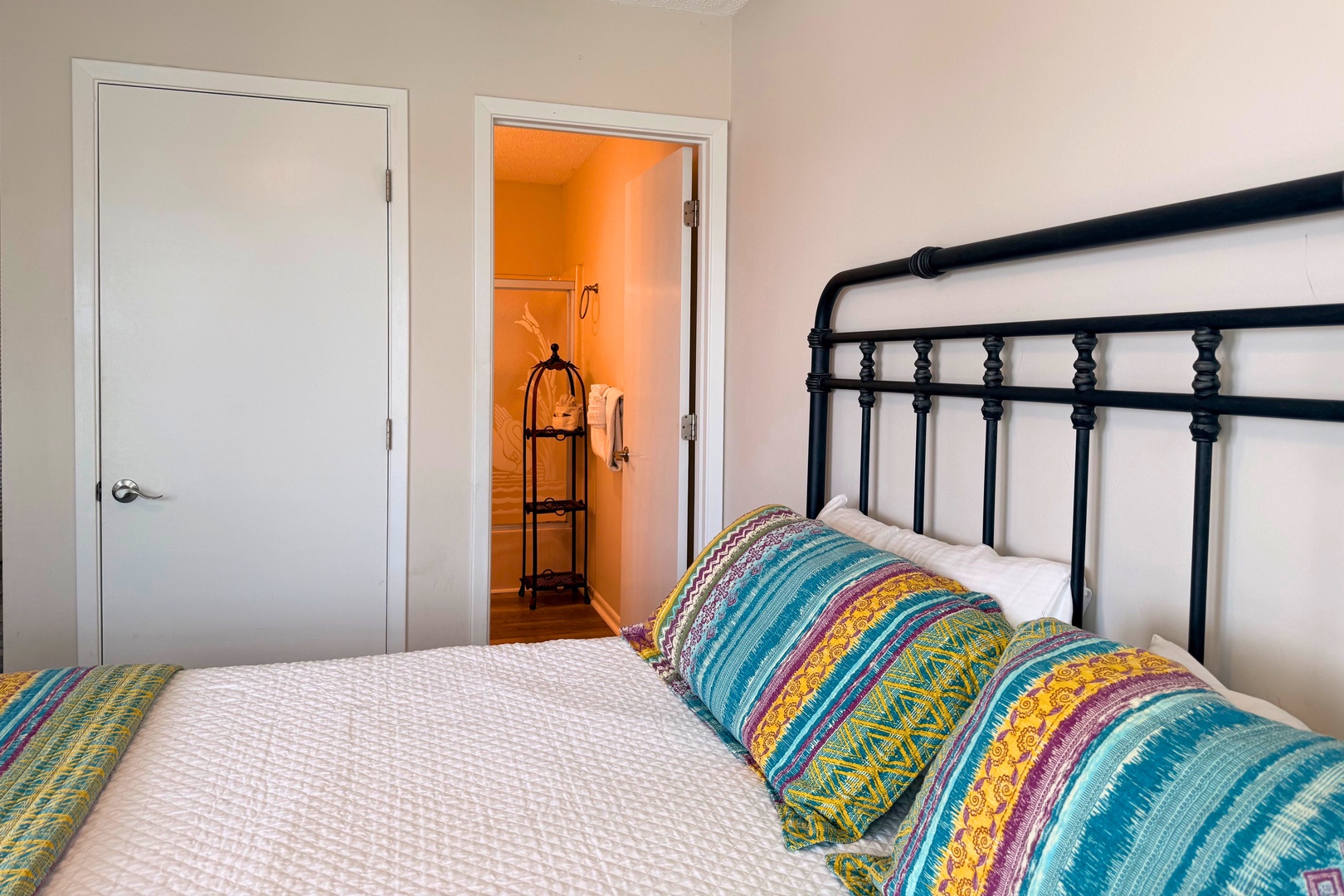 Settle into this charming primary bedroom with vibrant bedding and a cheerful wardrobe space just steps away—your cozy home base awaits.