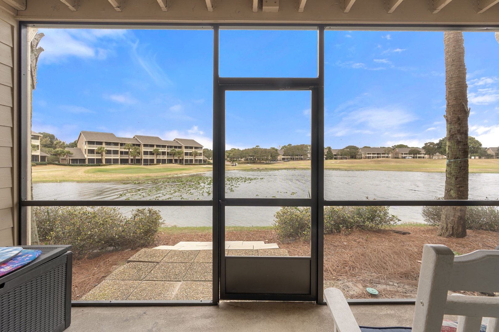 Relax on your private screened balcony with lake views, complete with comfortable furniture.