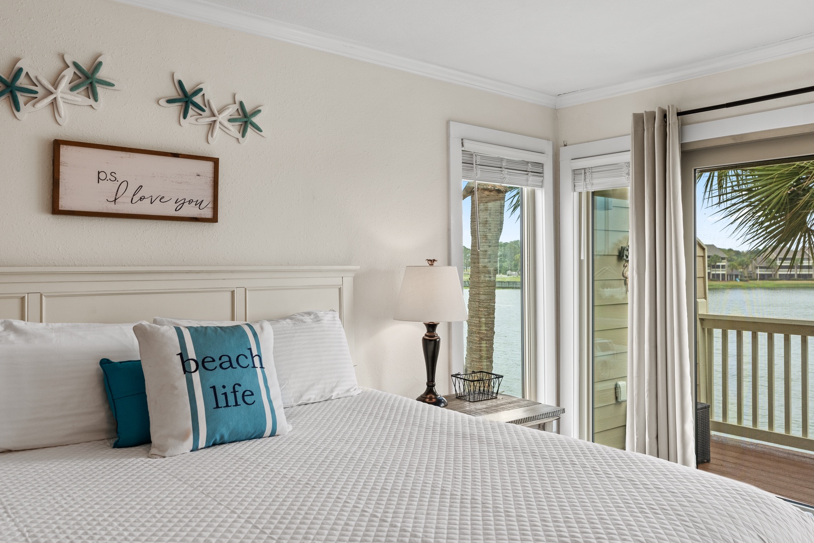 Wake up to stunning waterfront views from your cozy bedroom, where coastal charm meets comfort with thoughtful beach-themed touches.