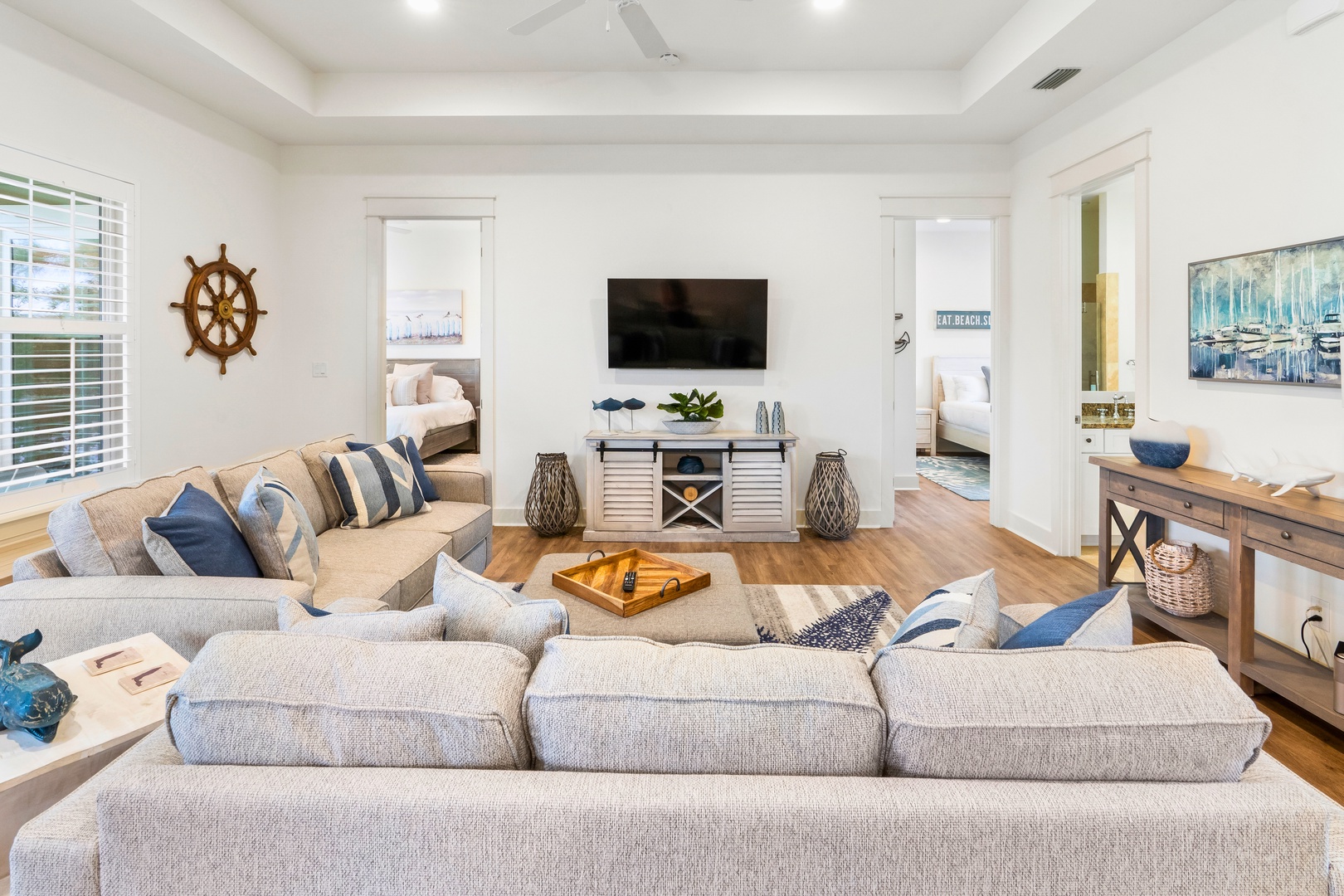 Unwind in your spacious coastal-themed living room featuring plush sectional seating and nautical touches that create the perfect gathering spot for relaxation.