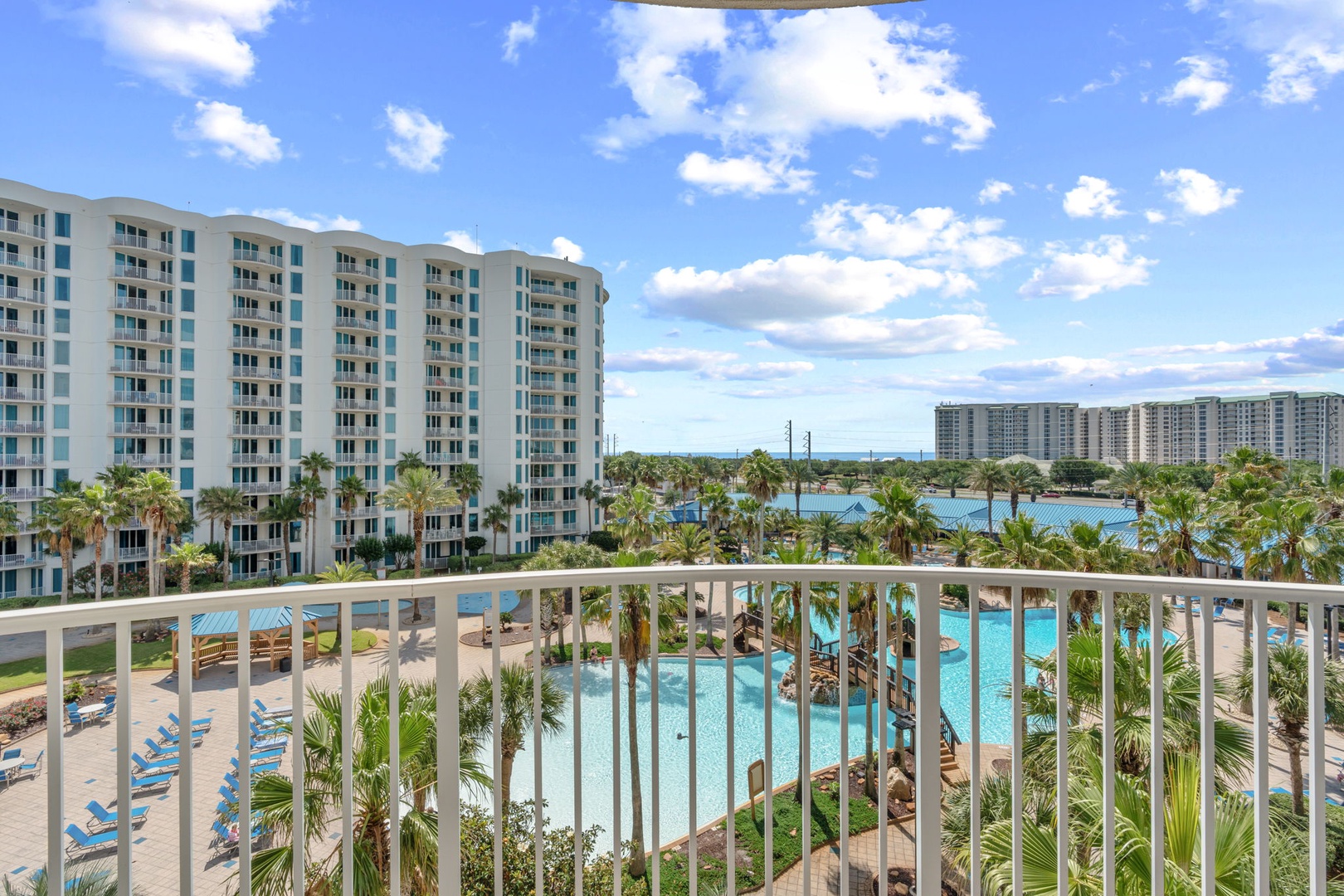 Wake up to stunning views of the sparkling lagoon-style pool, swaying palms, and waterfront beyond from your private balcony—a perfect escape to start your day in paradise.