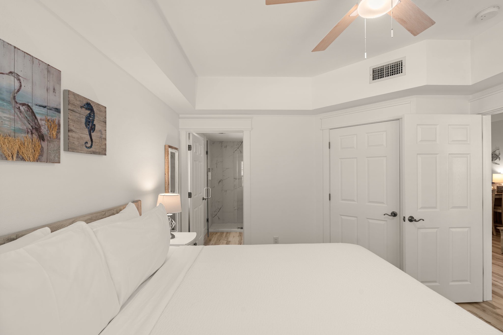 Drift off in this airy coastal bedroom with vaulted ceilings and a ceiling fan to keep you cool. Your private ensuite awaits just steps away, complete with modern glass shower.