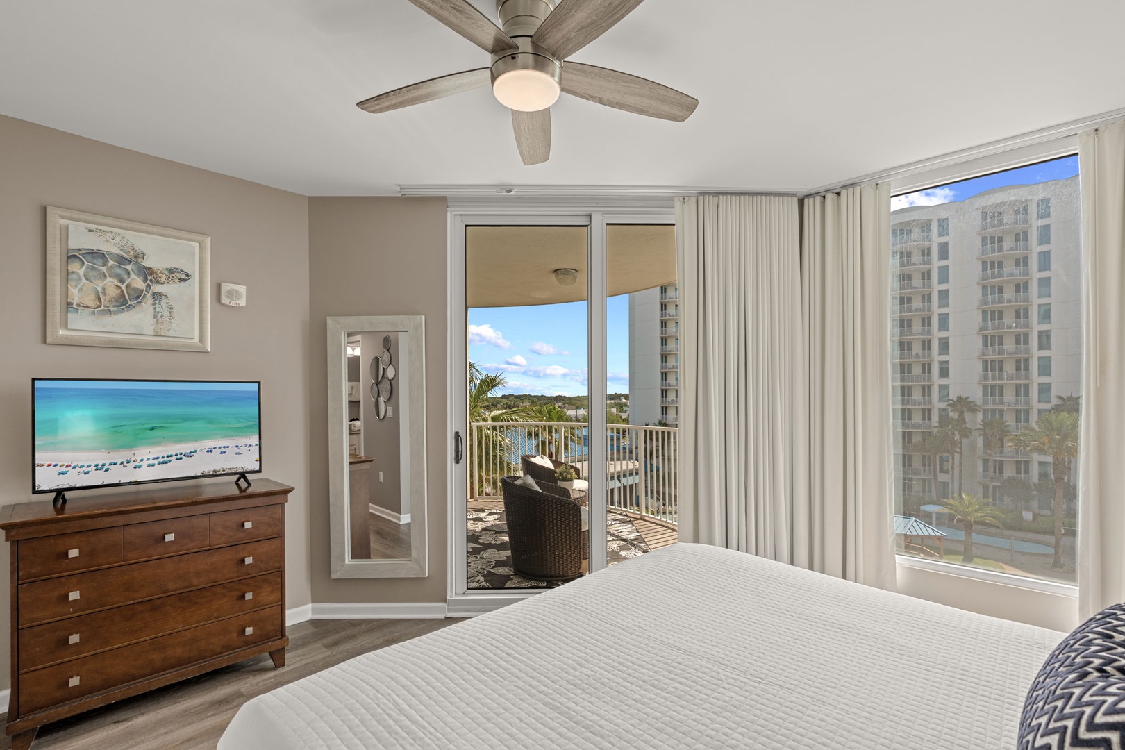 Sink into plush bedding as the ceiling fan keeps you cool and your private balcony beckons with coastal breezes and scenic views.
