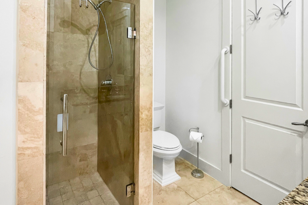 Clean coastal bathroom with tiled walk-in shower, glass enclosure, and bright, airy finishes.
