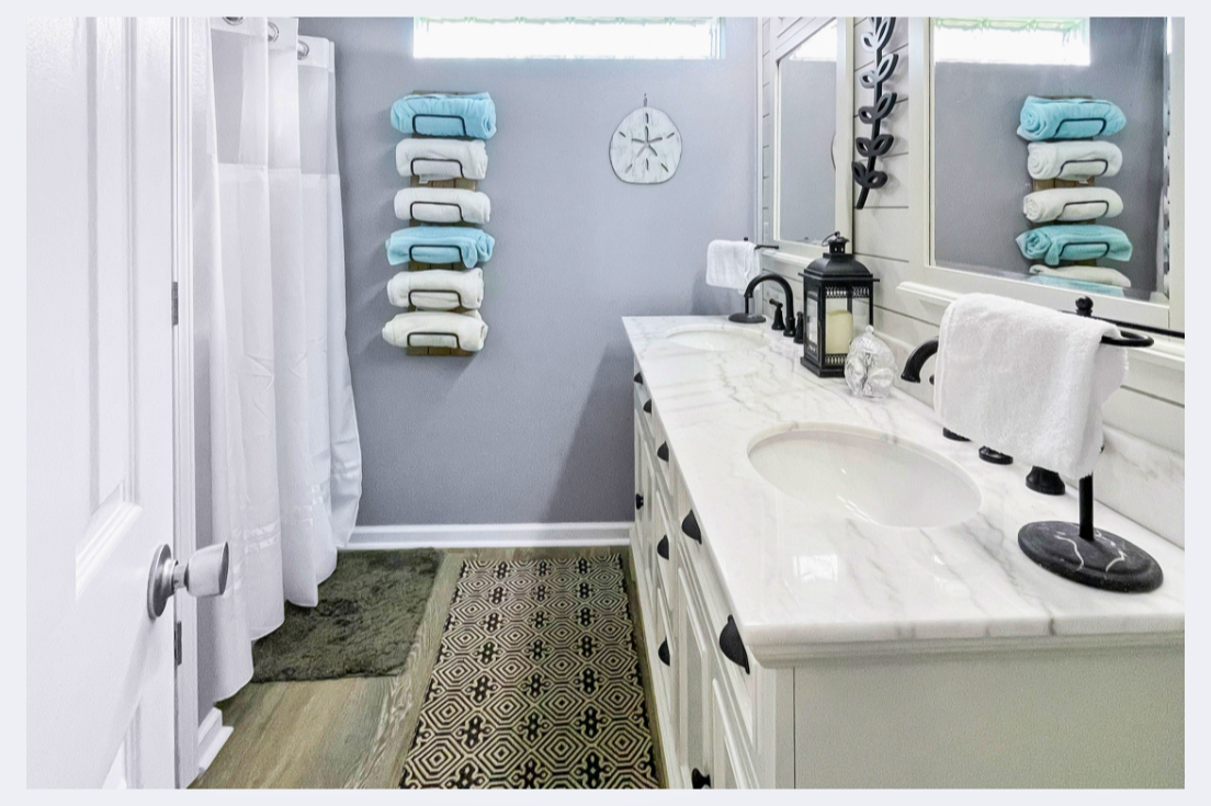 Step into your spa-like bathroom with marble countertops, soft towels, and coastal decor that creates a serene retreat for your morning routine.