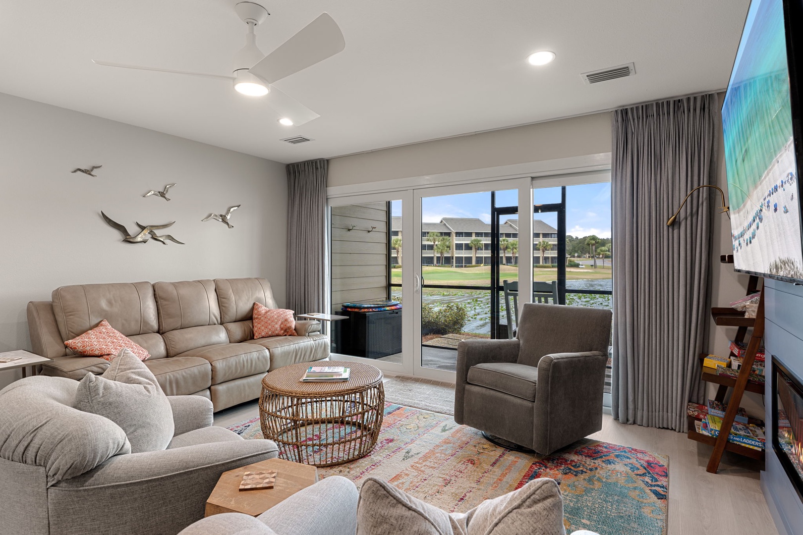 Sink into plush leather seating while enjoying serene water views from your bright living space with modern coastal touches.