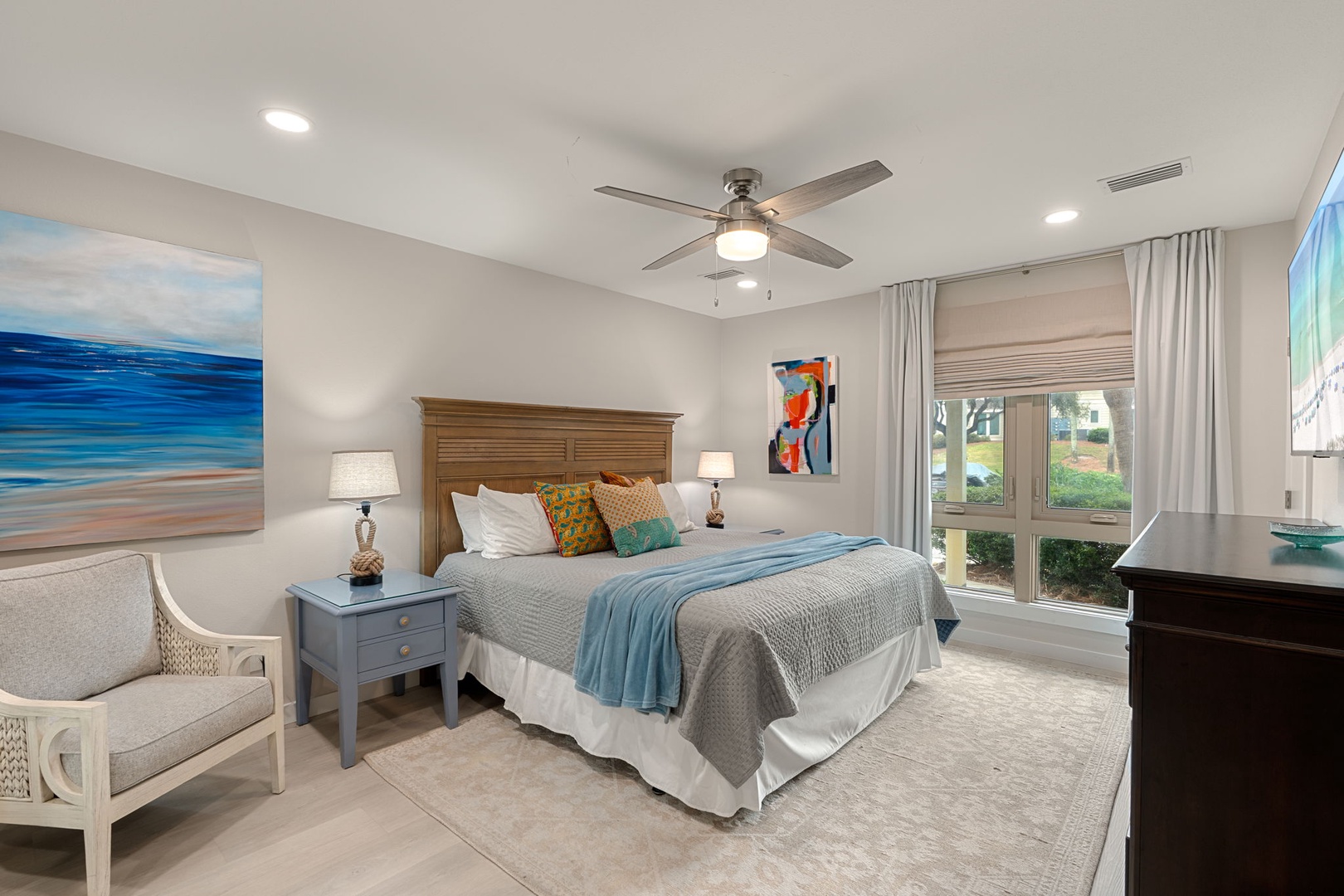 Unwind in your serene bedroom featuring coastal artwork, plush bedding, and a peaceful sitting area where you can relax after your adventures.