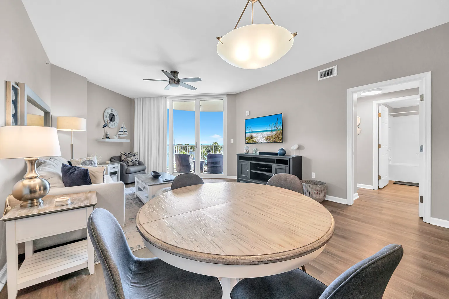 Step into your open-concept haven where coastal light fills the space through sliding doors to your private balcony.