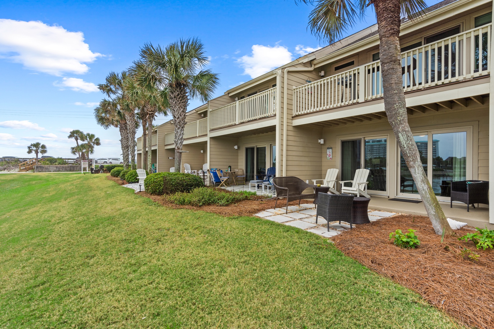 Beachfront property featuring palm trees and expansive lawn areas with private patios for guest units.