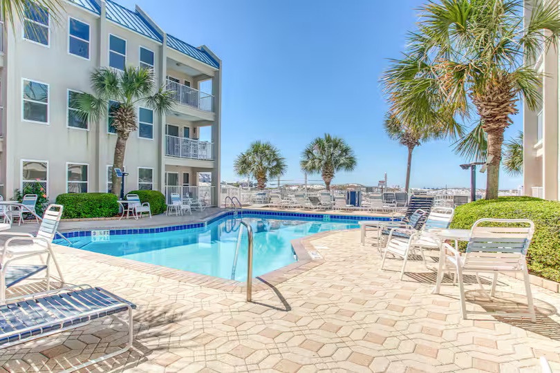 Beachfront pool with Gulf views, palm-lined deck, and plenty of loungers—relax just steps from the sand.