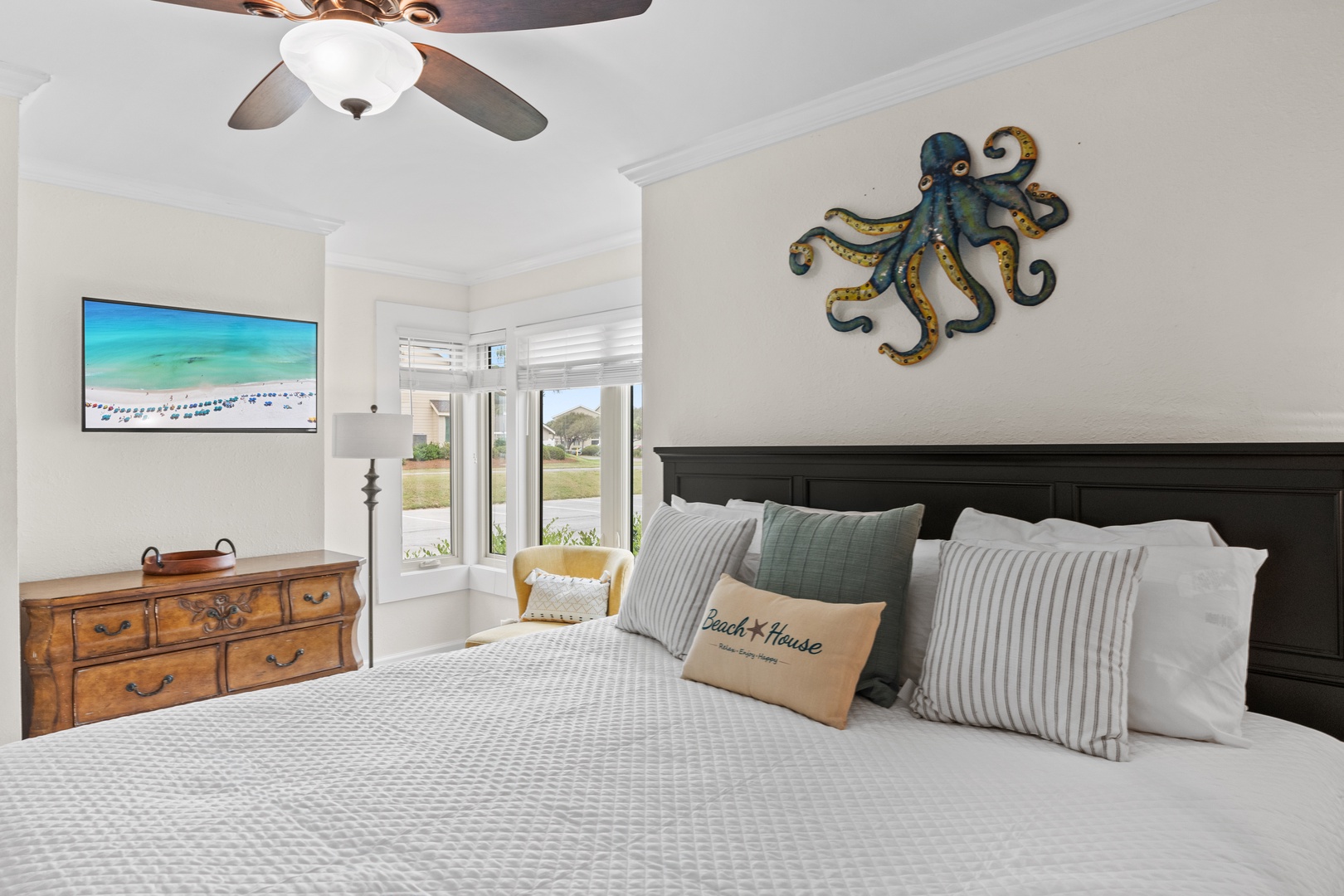 Unwind in your coastal-themed bedroom with ocean views, ceiling fan comfort, and charming nautical décor creating the perfect seaside retreat.