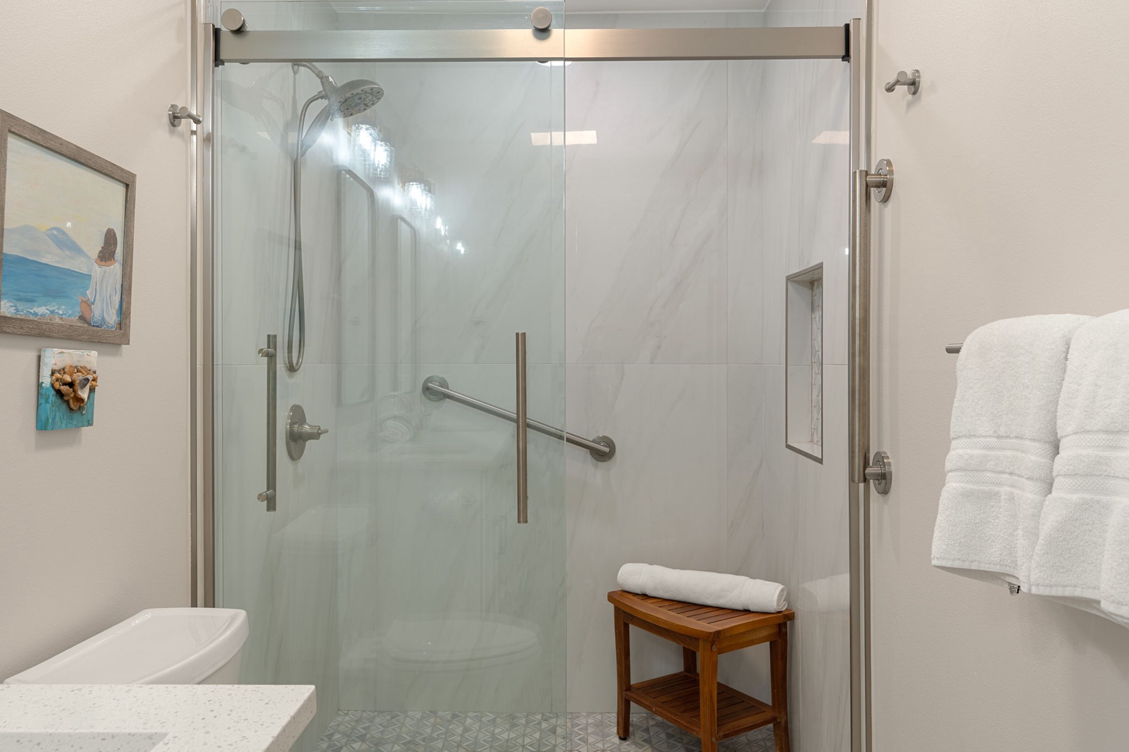 Step into your spa-like shower with rainfall head and elegant glass enclosure, where fluffy towels await your refreshing retreat.