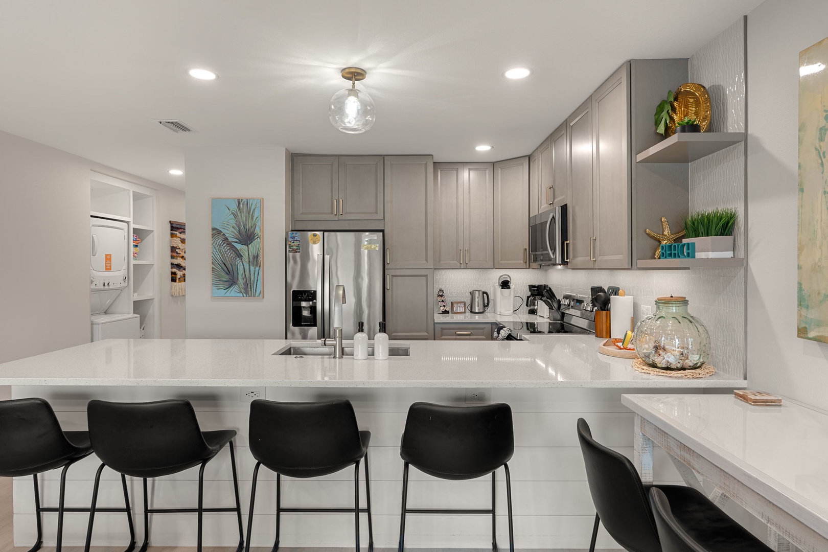 Your modern kitchen features sleek gray cabinets, stainless appliances, and a spacious island with bar seating for memorable meals together.