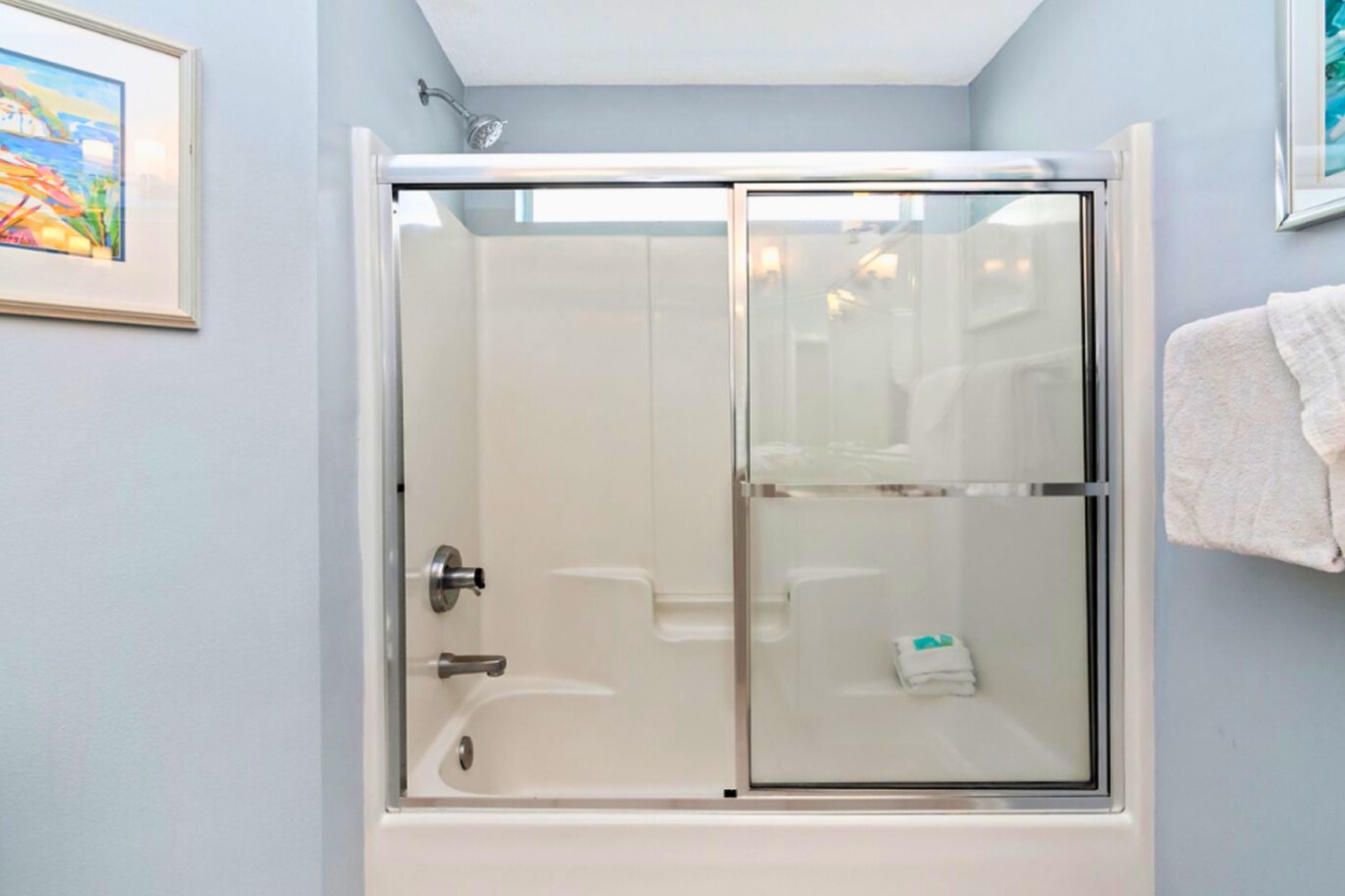 Unwind in your private bathroom with a spacious tub-shower combo and calming blue walls that create a spa-like retreat.
