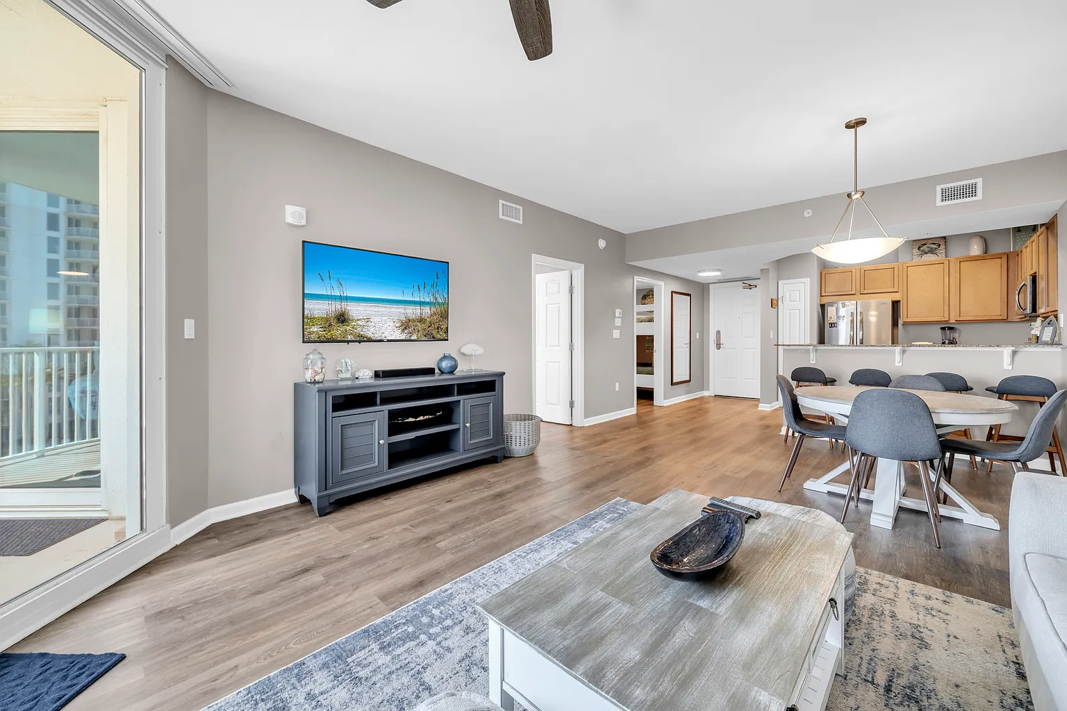 Step into your bright, open-concept living space where modern comfort meets coastal charm. Enjoy meals at the elegant dining table or unwind while watching your favorite shows.