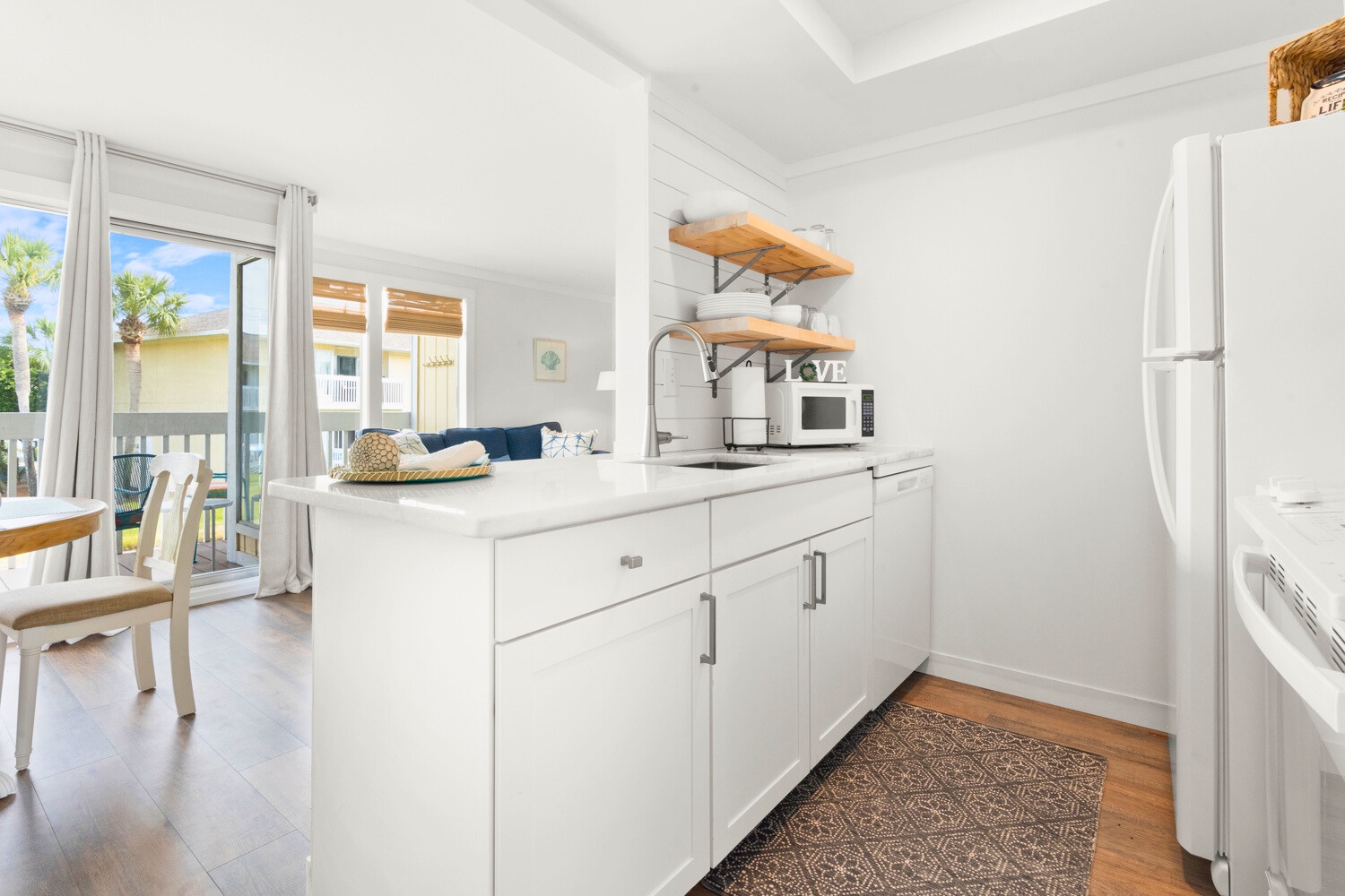 Step into your bright, modern kitchen featuring crisp white cabinets, open shelving, and everything you need to create memorable meals.