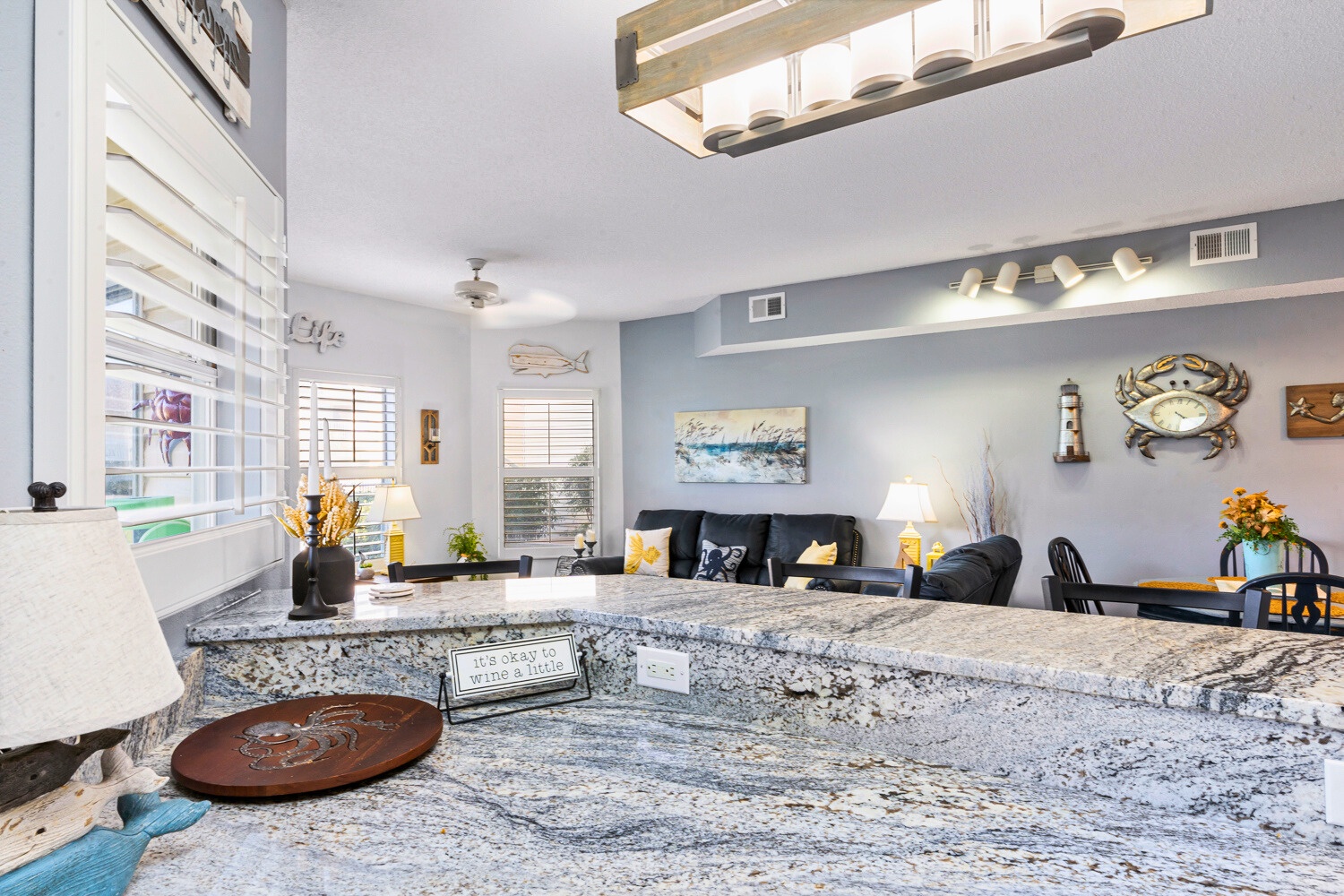 Your open-concept living space features stunning granite countertops perfect for meal prep, while coastal decor creates a relaxing atmosphere.