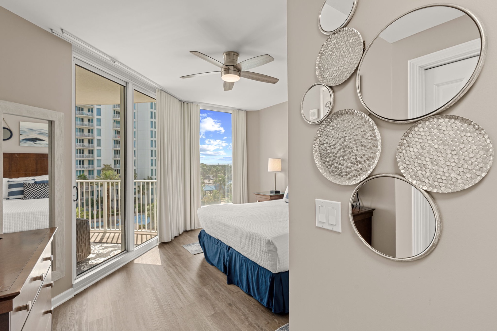 Relax in this bright bedroom with balcony access, serene lake views, and coastal-inspired décor that invites restful mornings and peaceful evenings.