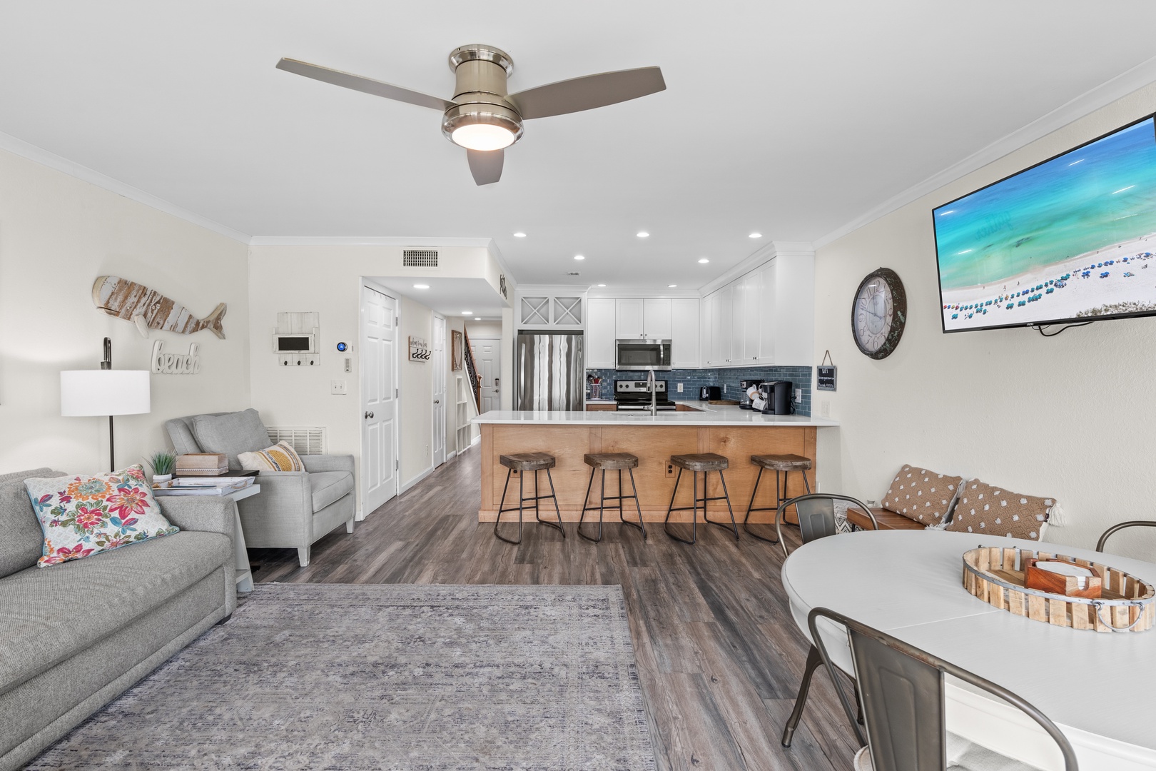 Relax in your open-concept haven with coastal décor, modern kitchen island seating, and cozy living space perfect for gathering.