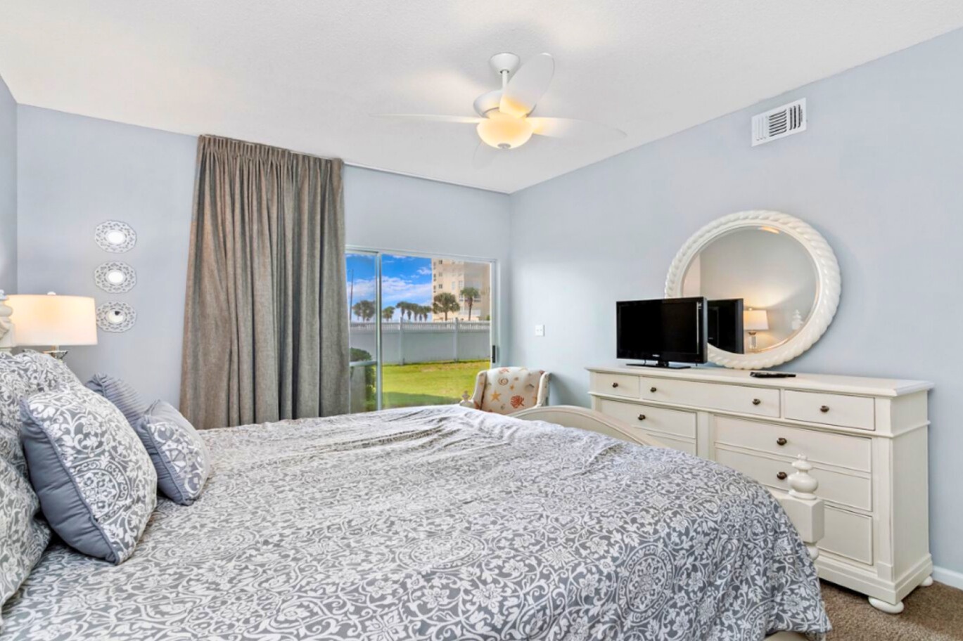 Drift off in your serene bedroom featuring soft blue walls, comfortable bedding, and peaceful garden views through your private window.